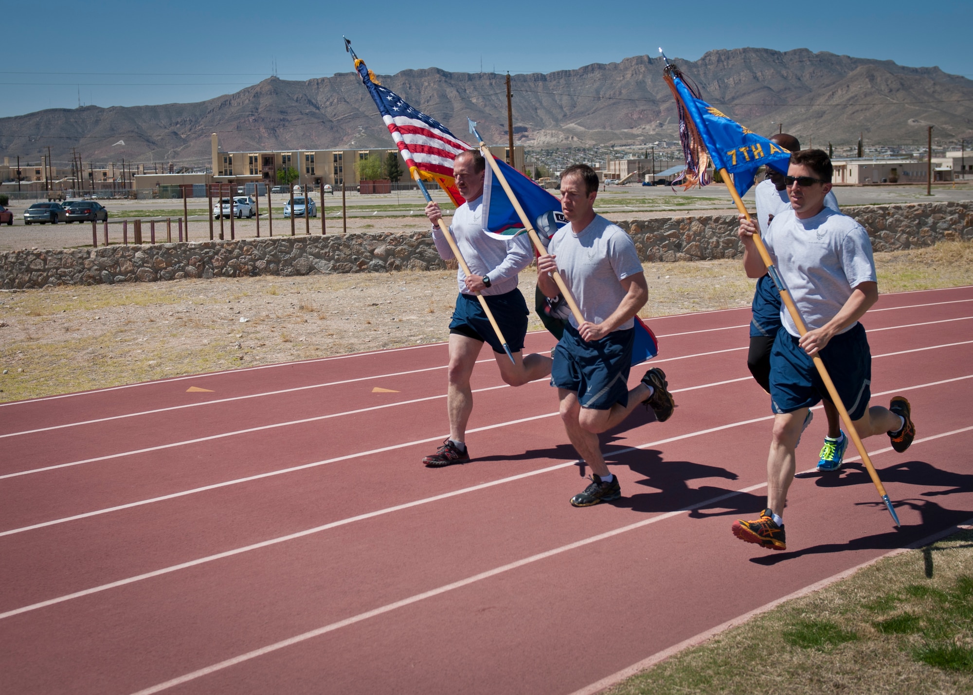 Leadership with the 7th Air Support Operations Squadron Tactical Air Control Party run the first lap of the 24-hour Remembrance Run with the United States, TACP and squadron flags at Fort Bliss, Texas, March 26, 2015. Each year, TACP units from across the Air Force run for 24-hours in honor of those who made the ultimate sacrifice. Each unit raises money and collects donations that go toward the TACP foundation. (U.S. Air Force photo by Airman 1st Class Emily A. Kenney/Released)  