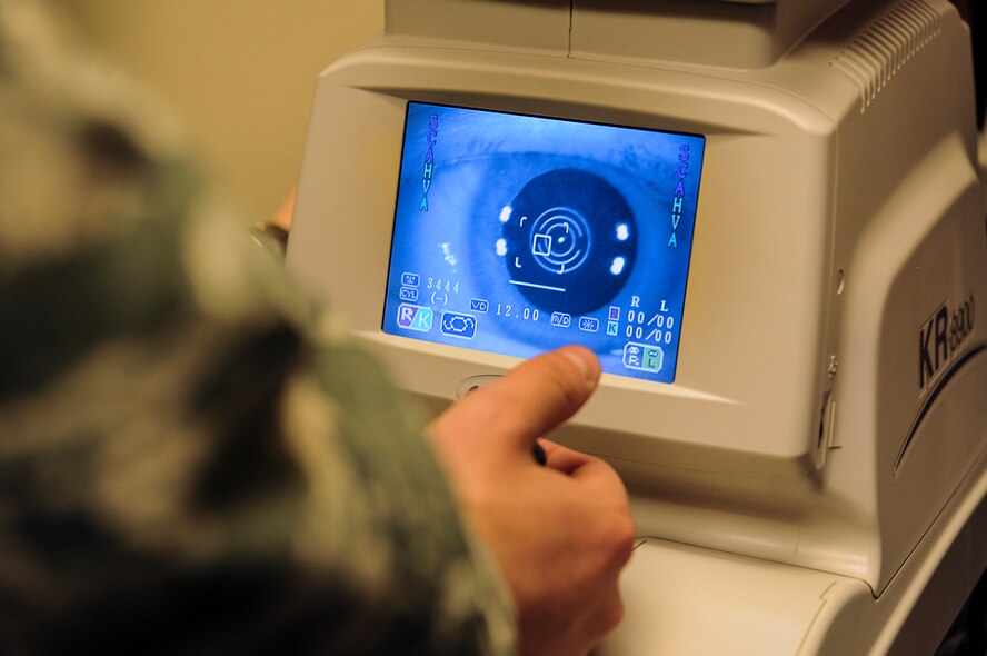 Airman Julian Carbajal, 5th Medical Operations Squadron optometry technician, uses an auto refractor to examine a patient’s eye in the optometry clinic on Minot Air Force Base, N.D. March 23, 2015. The refractor provides an objective measurement of a person’s refractive error by measuring how light is changed when it enters the eye. (U.S. Air Force photo/Senior Airman Stephanie Morris)