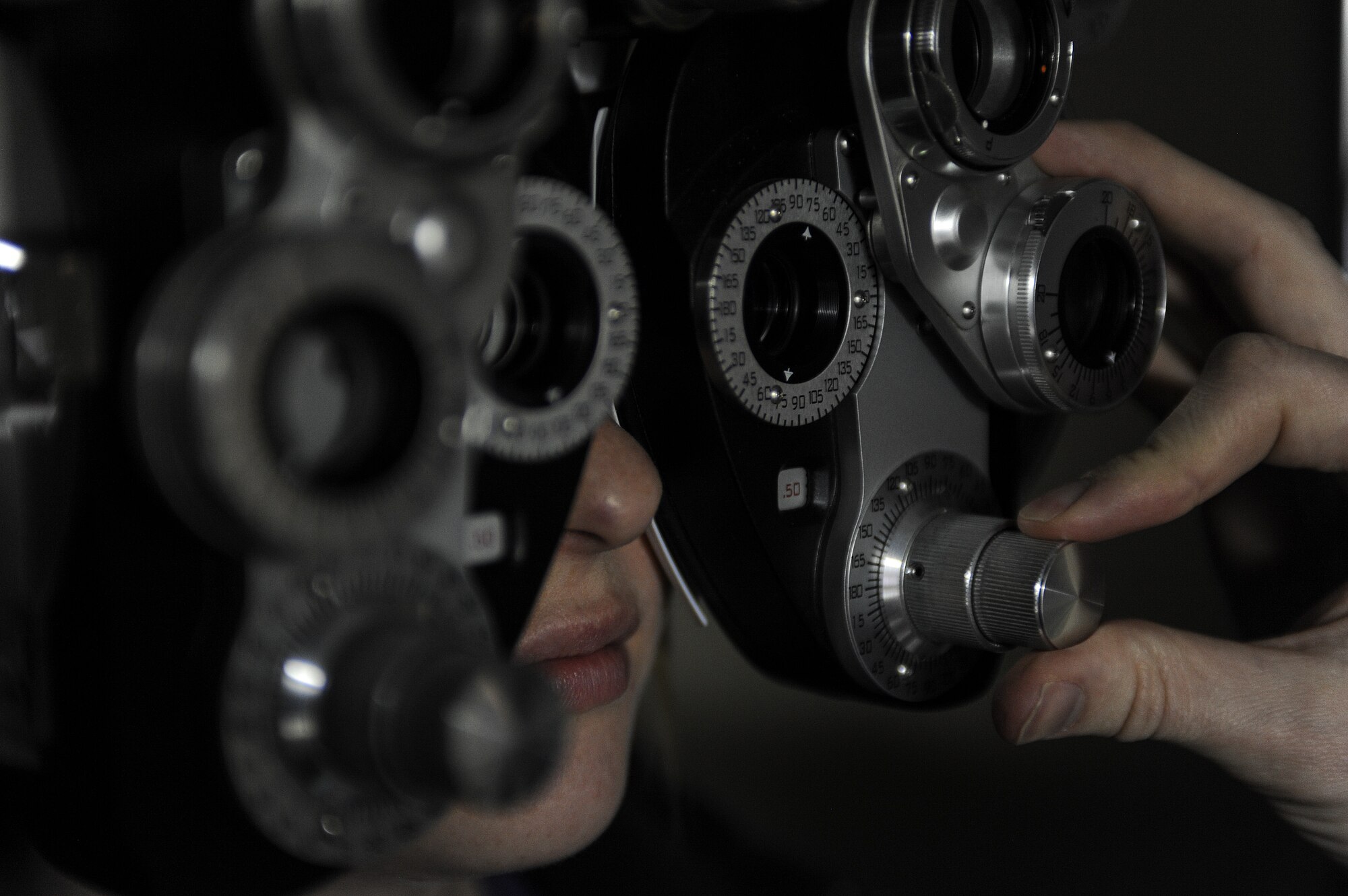 Capt. Makay Neilson, 5th Medical Operations Squadron optometrist, makes adjustments to a phoropter in the optometry clinic on Minot Air Force Base, N.D., March 23, 2015. A phoropter uses several different lenses to discern a person’s prescription. (U.S. Air Force photo/Senior Airman Stephanie Morris)