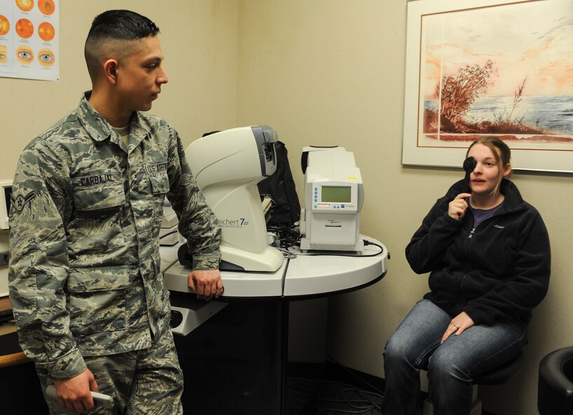 Airman Julian Carbajal, 5th Medical Operations Squadron optometry technician, listens for mistakes as Chelsea Hanson reads from a chart on Minot Air Force Base, N.D., March 23, 2015. Carbajal also administered tests for eye pressure and peripheral vision. (U.S. Air Force photo/Senior Airman Stephanie Morris)