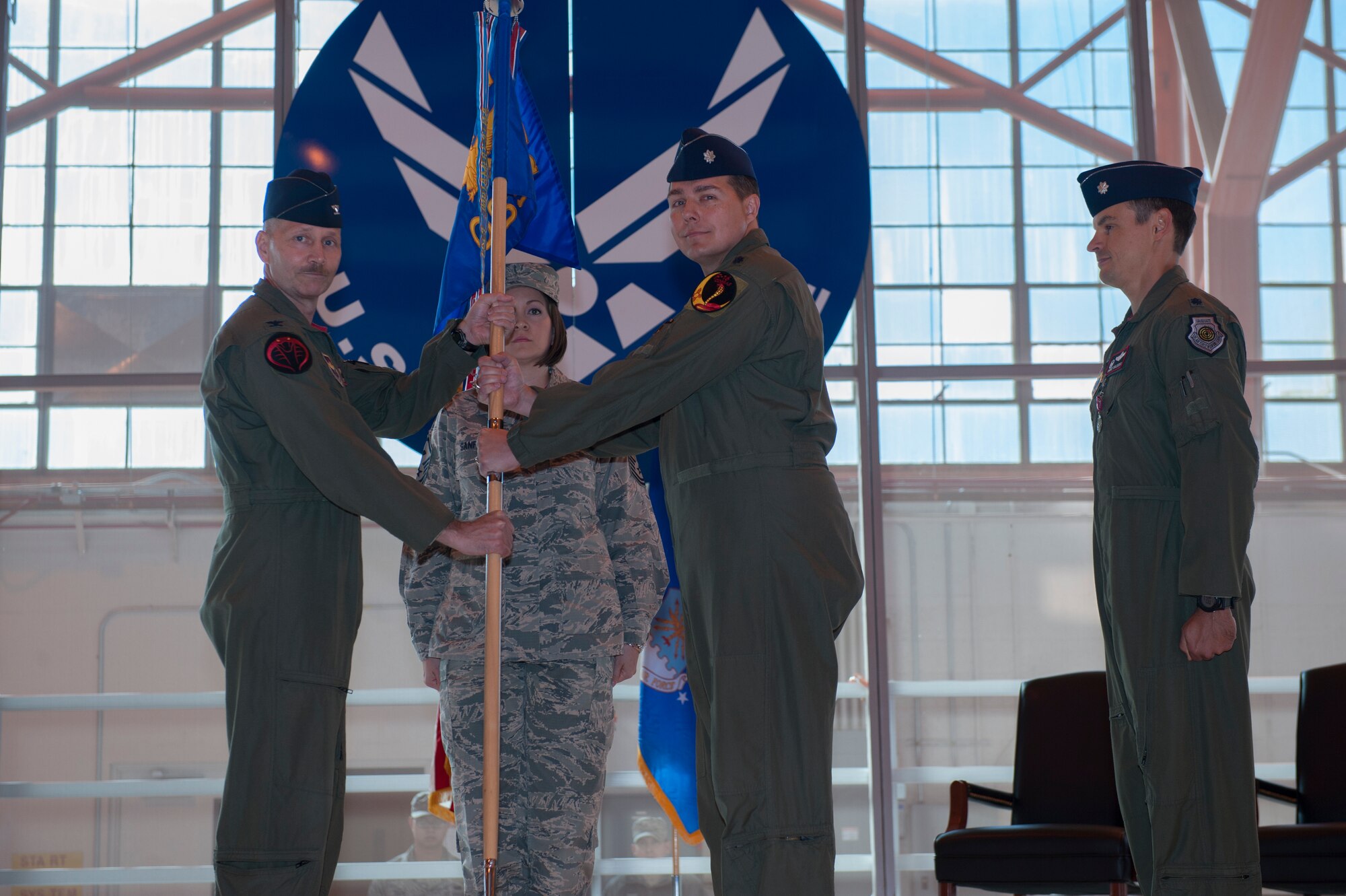 Lieutenant Colonel Jerod Rick, 54th Operations Support Squadron incoming commander, accepts the 54th OSS guidon from Col. Jeff Jensen, 54th Fighter Group commander, symbolizing assuming command of the squadron during the 54th OSS change of command at Holloman Air Force Base, N.M., March 27, 2015. In the ceremony, Lt. Col. Jerod Rick assumed command of the 54th OSS from Lt. Col. Marshall Chalverus. The 54th OSS is a fighter training unit that trains 45 percent of all F-16 Falcon student pilots. They also manage Intelligence, Air Crew Flight Equipment, and Simulator and Training Devices. (U.S. Air Force photo by Airman 1st Class Emily Kenney / Released)