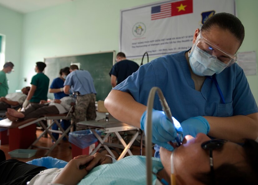 U.S. Air Force Tech. Sgt. Elizabeth Douglas, 18th Dental Squadron dental technician, Kadena Air Base, Japan, performs a cleaning on a dental patient at Duc Pho vocational training school, Quang Ngai Province, Vietnam, during a Operation Pacific Angel 15-3 health service outreach event, March 27, 2015. Pacific Angel is a multilateral humanitarian assistance civil military operation, which improves military-to-military partnerships in the Pacific while also providing medical health outreach, civic engineering projects and subject matter exchanges among partner forces. (U.S. Air Force photo by Staff Sgt. Tong Duong/ Released)