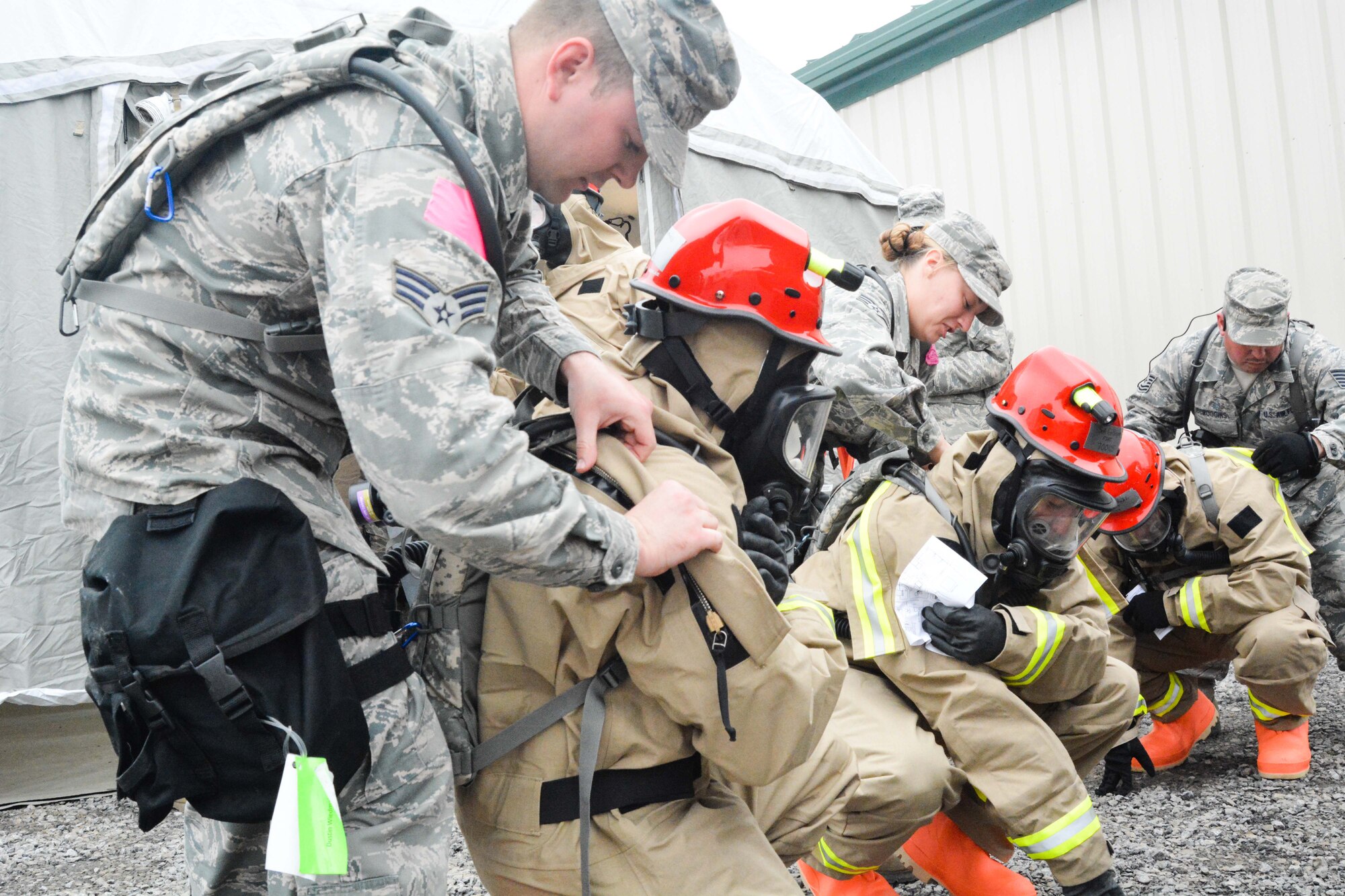 U.S. Airmen assigned to the Fatality Search and Recovery Team of the Missouri National Guard's Homeland Response Force don protective equipment at Camp Gruber in Braggs, Okla., March 19, 2015. The guardsmen were evaluated on their ability to respond to a large scale natural disaster or terrorist attack. (U.S. Air National Guard photo by Airman 1st Class Chayla Hurd/Released)