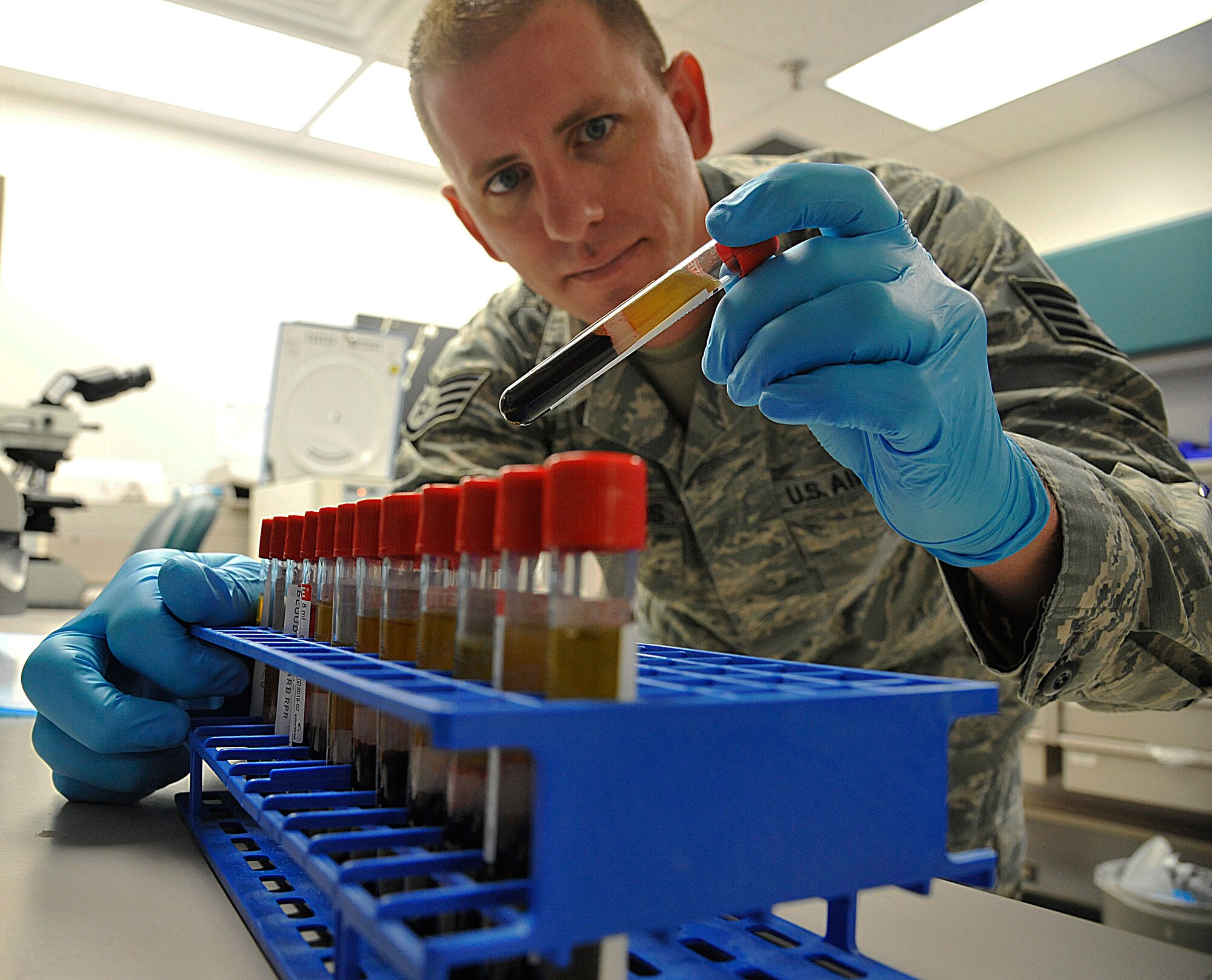 U.S. Air Force Staff Sgt. Jon Rigenoldus, 509th Medical Support Squadron medical lab technician, examines samples at Whiteman Air Force Base, Mo., March 18, 2015. Once samples are examined, they are processed and shipped to reference laboratories for advanced testing. (U.S. Air Force photo by Senior Airman Keenan Berry/Released)