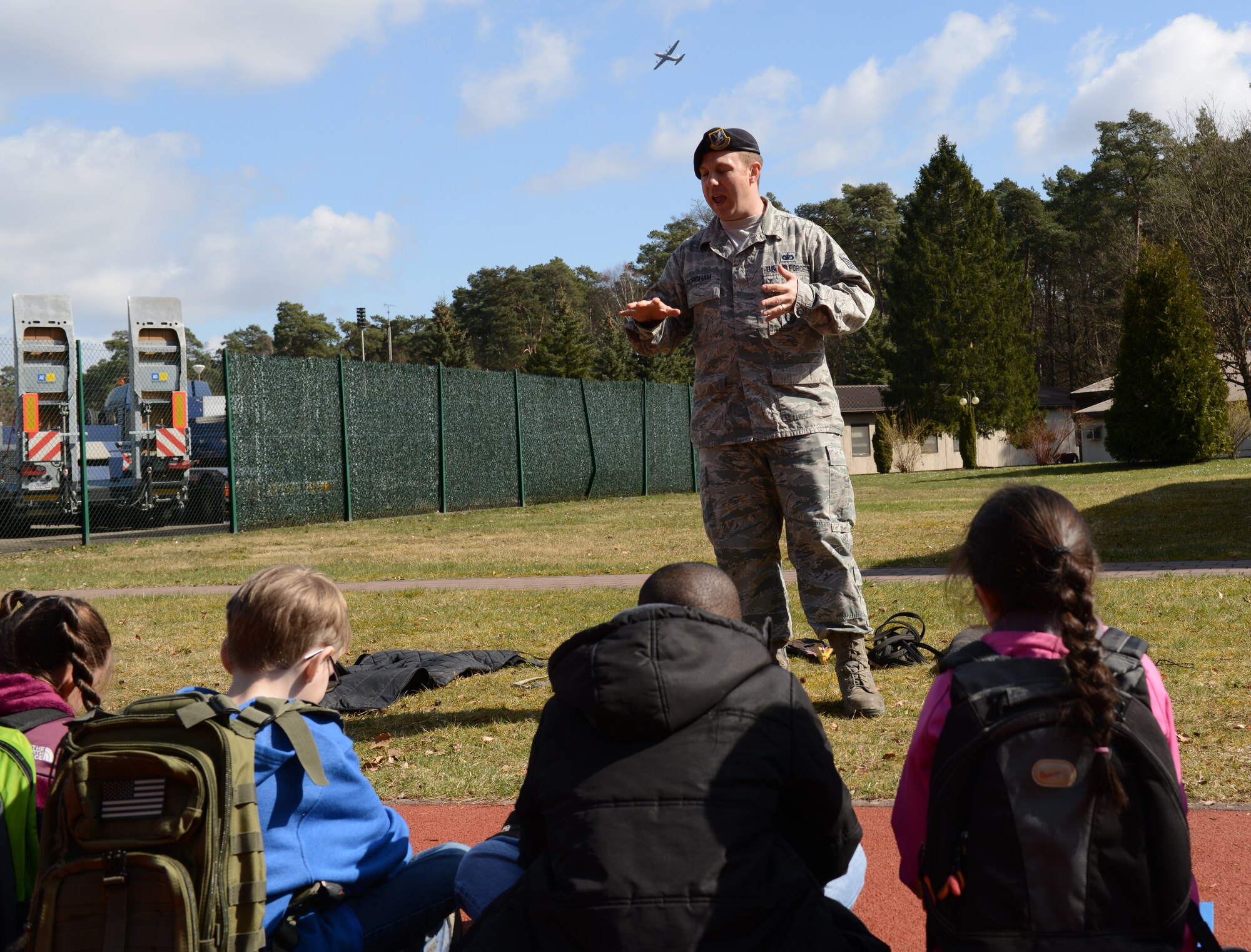 Staff Sgt. Jonathan Forgham, 86th Security Forces Squadron military working dog trainer, answers question from intermediate students about varying aspects of the job for military working dog handlers and their canines as part of a demonstration 27 March, 2015, at Ramstein Air Base, Germany. The demonstration was to show how a handler and their canine respond to various situations with a possible perpetrator. (U.S. Air Force photo/A1C Tryphena Mayhugh)