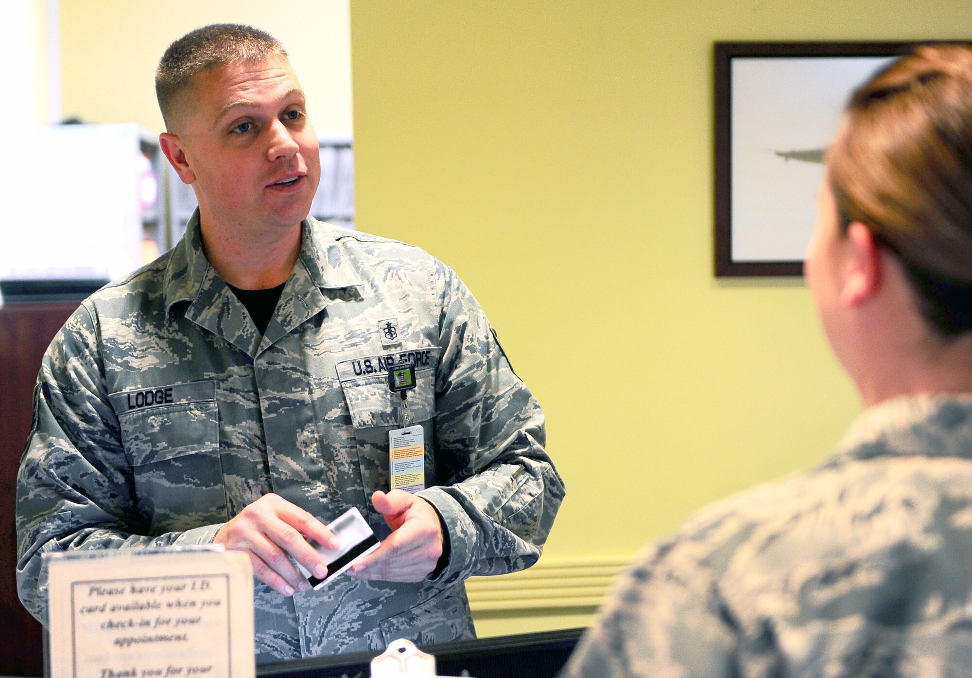 Tech. Sgt. William Lodge, 14th Medical Operations Squadron Dental Flight Chief, greets a patient and checks her in for an appointment March 20 at Columbus Air Force Base, Miss. For more information on the dental flight and its services or to make an appointment, call 434-2250. (U.S. Air Force photos/Senior Airman Kaleb Snay)