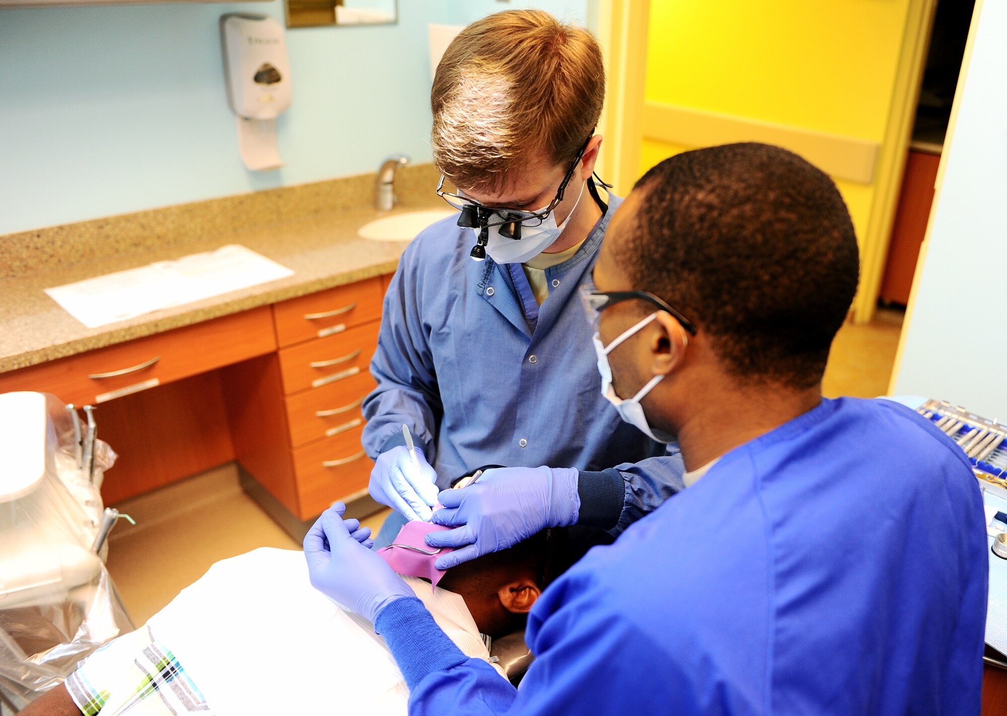 Capt. Christopher Loftin, 14th Medical Operations Squadron Dentist, assisted by Senior Airman Robert Woods III, 14th MDOS Dental Assistant, checks a patient’s teeth March 20 at Columbus Air Force Base, Miss. The dental flight serves active-duty personnel from both the base and local area. (U.S. Air Force photos/Senior Airman Kaleb Snay)