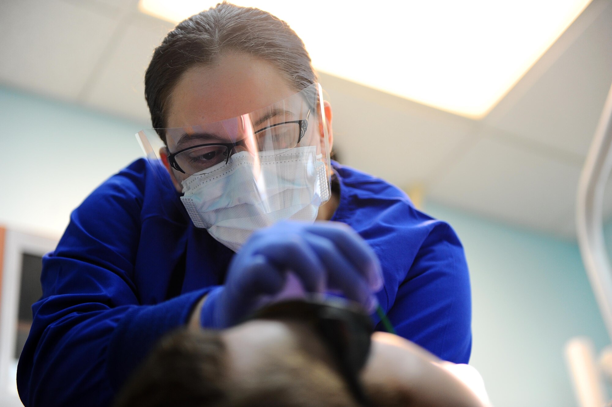 Airman 1st Class Emily Miller, 14th Medical Operations Squadron Dental Assistant, applies fluoride varnish to a patient’s teeth March 20 at Columbus Air Force Base, Miss. The dental flight takes care of general dentistry, oral surgery, preventative dentistry and several dental lab cases for active-duty personnel. (U.S. Air Force photos/Senior Airman Kaleb Snay)