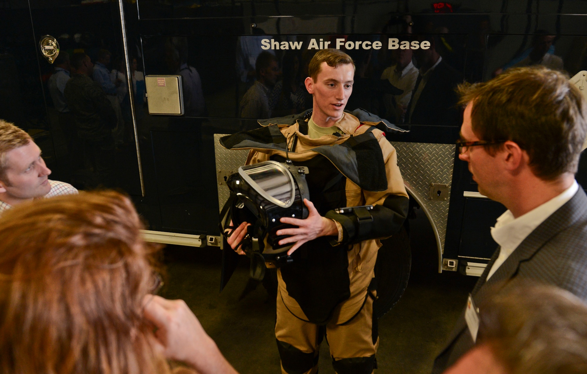 U.S. Air Force Airman 1st Class Tyler McMillan-Wammack, 20th Civil Engineer Squadron explosive ordnance disposal apprentice, speaks to honorary commanders of the community the EOD 9 bomb suit and helmet at Shaw Air Force Base, S.C., March 17, 2015. The honorary commander program was initiated 15 years ago to promote public awareness of the missions, policies, and programs of Shaw AFB. (U.S. Air Force photo by Senior Airman Tabatha Zarrella/Released)