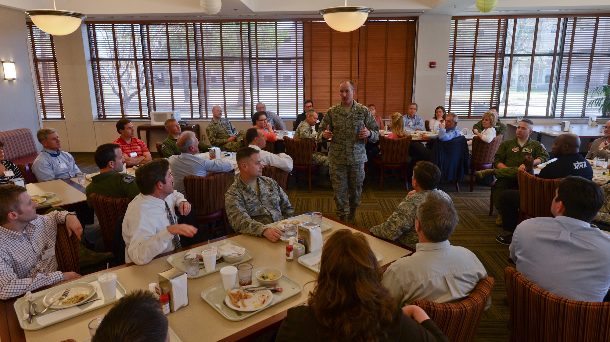 U.S. Air Force Col. Stephen Jost, 20th Fighter Wing commander, speaks with commanders and their appointed honorary commanders during lunch at the Chief Emerson Dining Facility, Shaw Air Force Base, S.C., March 17, 2015. As part of the honorary commander program, an annual tour is held to show the community Shaw AFB missions. (U.S. Air Force photo by Senior Airman Tabatha Zarrella/Released)