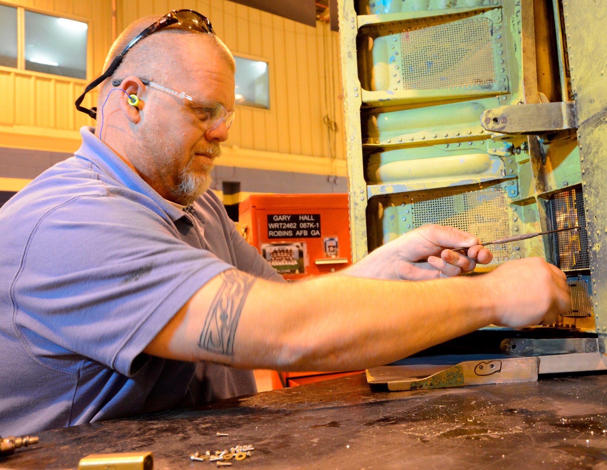Gary Hall, 572nd Commodities Maintenance Squadron sheet metal mechanic, reinstalls an interior screen after removing foreign objects from inside of an F-15 Intake Ramp. (U.S. Air Force photo by Ed Aspera)
