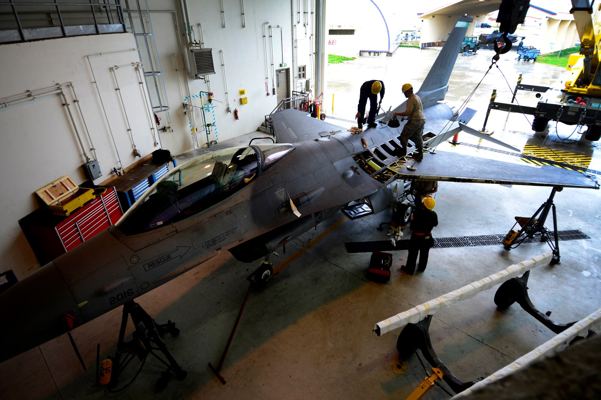 U.S. Air Force Airmen with the 31st Maintenance Squadron prepare to remove a wing from an F-16 Fighting Falcon, March 25, 2015 at Aviano Air Base, Italy. Replacement of the wing required at least a four-man crew at all times for efficiency and safety purposes. (U.S. Air Force photo by Senior Airman Areca T. Wilson/Released)