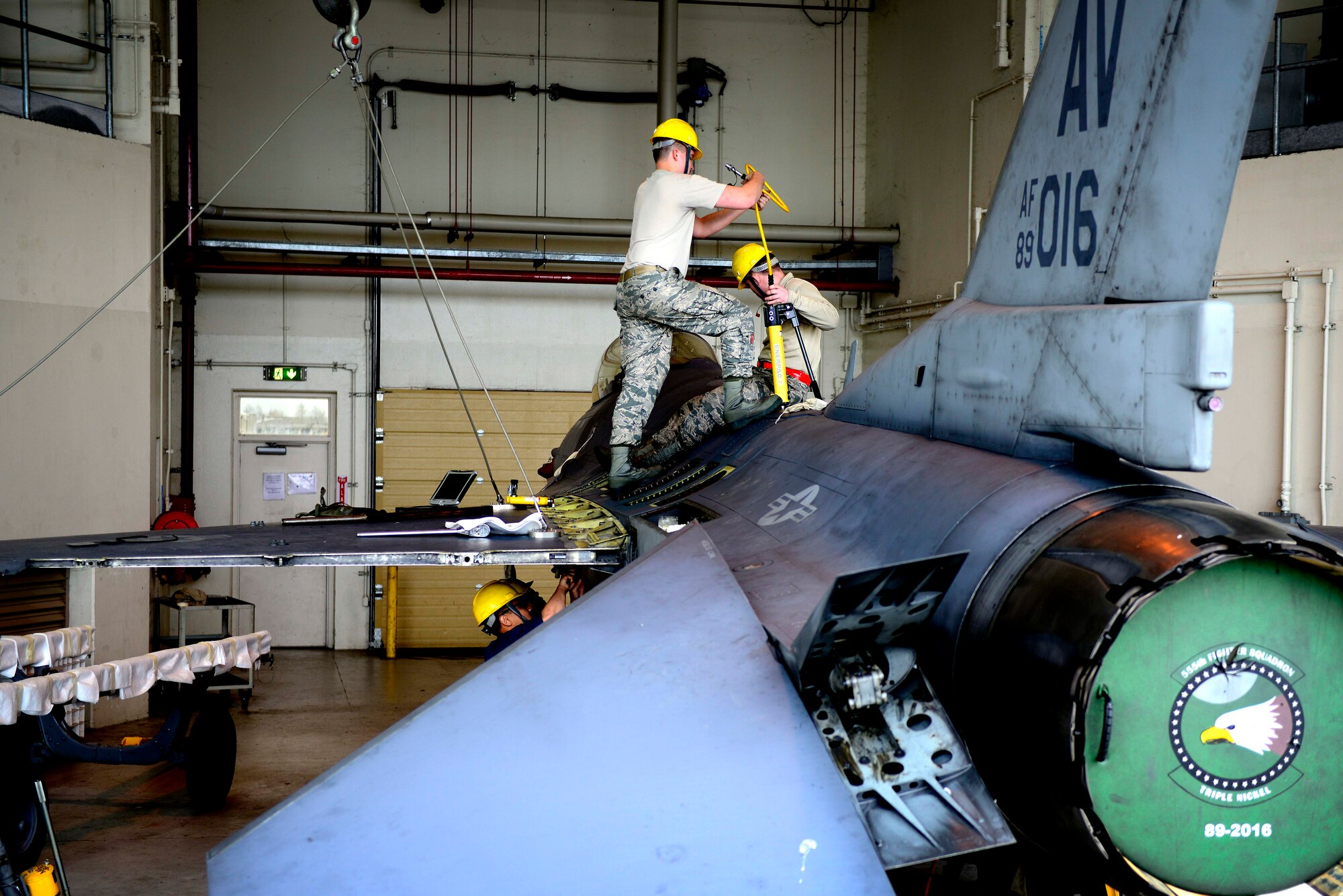 U.S. Air Force Airmen with the 31st Maintenance Squadron prepare to remove a wing from an F-16 Fighting Falcon, March 25, 2015 at Aviano Air Base, Italy. Replacement of the wing required at least a four-man crew at all times for efficiency and safety purposes. (U.S. Air Force photo by Senior Airman Areca T. Wilson/Released)