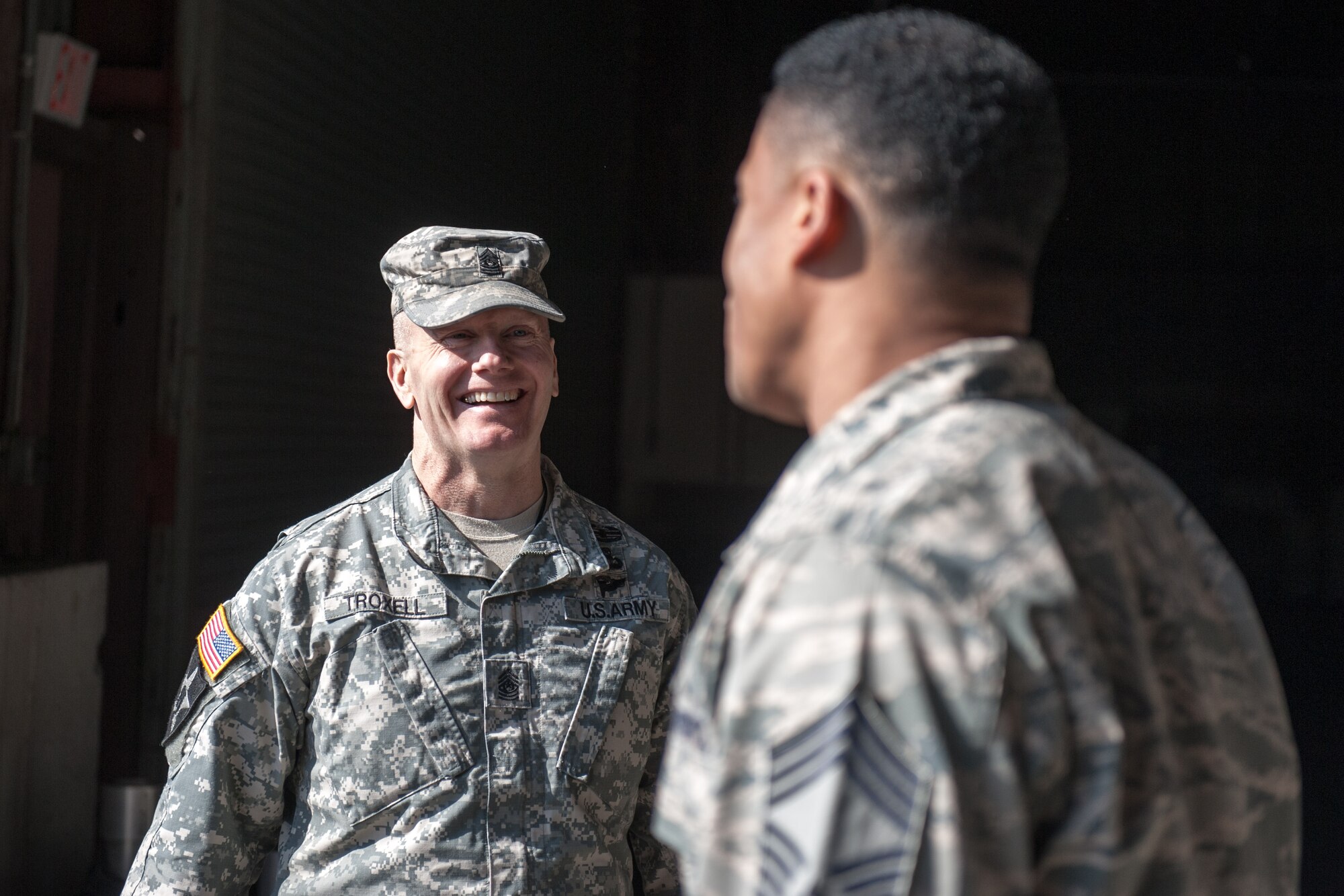 Army Sgt. Maj. John Troxell, U.S. Forces Korea Command Sgt. Maj., talks with Chief Master Sgt. Damion Peterson, 8th Logistics Readiness Squadron deployment and distribution chief, during Troxell’s visit to Kunsan Air Base, Republic of Korea, March 23, 2015. During his visit, Troxell saw how the Wolf Pack contributes to deterring aggression on the Korean Peninsula and remains ready to fight tonight. (U.S. Air Force photo by Senior Airman Taylor Curry/Released)