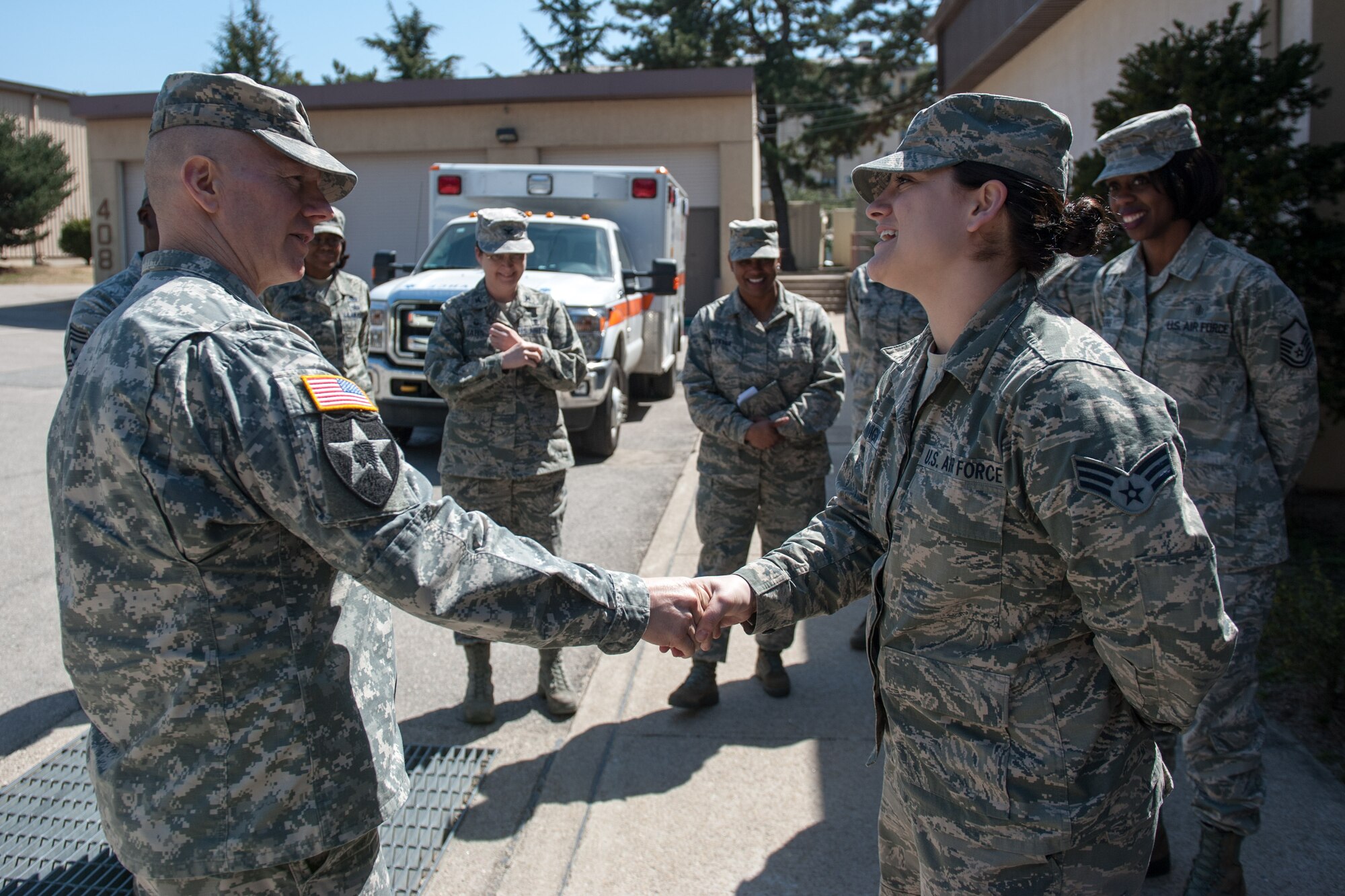 Army Sgt. Maj. John Troxell, U.S. Forces Korea Command Sgt. Maj., recognizes Senior Airman Britanni McKnight, 8th Medical Operations Squadron dental technician, for her excellent performance at Kunsan Air Base, Republic of Korea, March 23, 2015. During his visit, he saw how the Wolf Pack contributes to deterring aggression on the Korean Peninsula and remains ready to fight tonight. (U.S. Air Force photo by Senior Airman Taylor Curry/Released) 