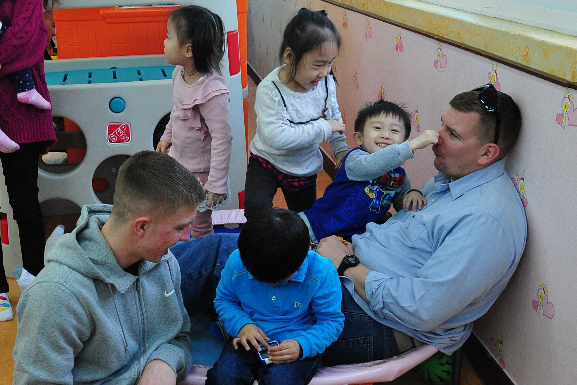 Airmen from the 120th Expeditionary Aircraft Maintenance Unit and 8th Fighter Wing play with children at the Moses Infant Home in Gunsan City, Republic of Korea, March 21, 2015. The Kunsan Chapel provided a special opportunity for the deployed Redeyes to volunteer in Gunsan while deployed to the ROK. (U.S. Air Force photo by Capt. Reba Good/Released)