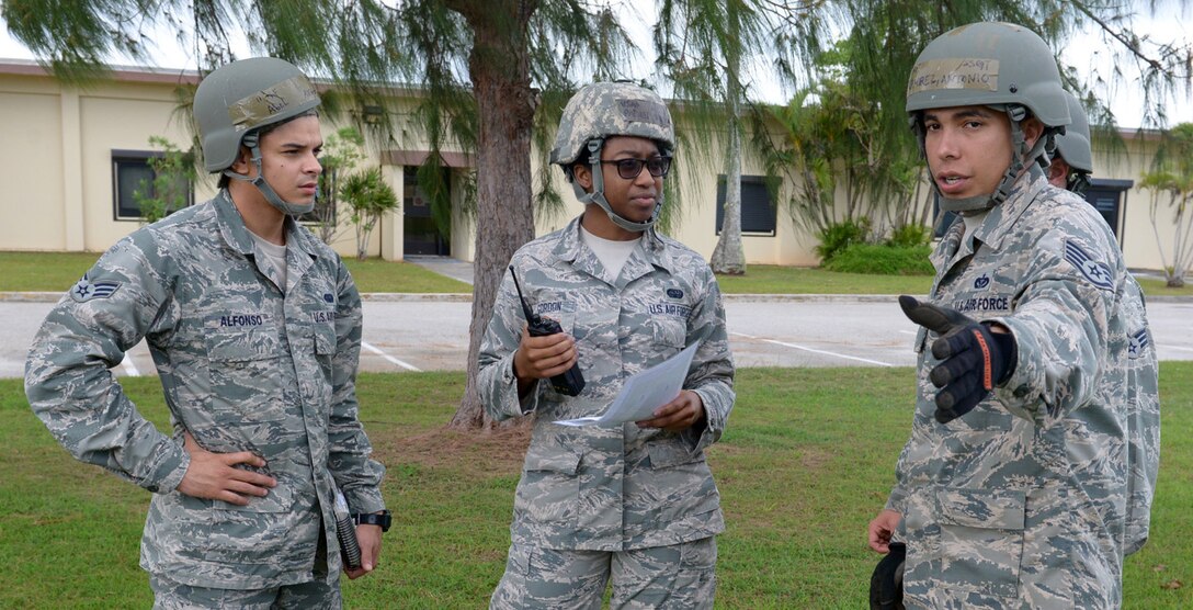 Senior Airman Abel Alfonso, 36th Communications Squadron cyber surety technician, and Airman 1st Class Paislei Gordon, 36th CS communication security accountant, speak to Staff Sgt. Antonio Ramirez, 36th Civil Engineer Squadron damage assessment repair team member, about possible damage to a facility during an operational readiness exercise March 25, 2015, at Andersen Air Force Base, Guam. Andersen Airmen practiced their ability to react, defend and execute operations in various scenarios during the exercise.  (U.S. Air Force photo by Airman 1st Class Joshua Smoot/Released)