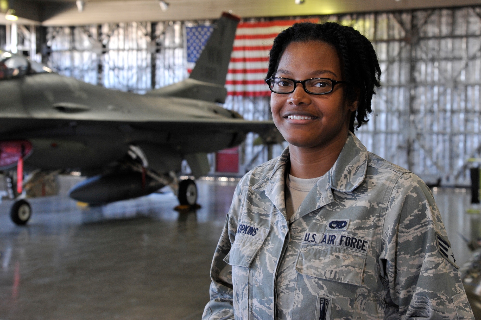 U.S. Air Force Senior Airman Kayla Hopkins, 35th Maintenance Group weapons load crew evaluator, poses in front of an F-16 Fighting Falcon at Misawa Air Base, Japan, Mar. 26, 2015. Hopkins’ responsibilities include instructing new Airmen on how to load weapons efficiently and ensuring experienced load crews maintain standards. (U.S. Air Force photo by Airman 1st Class Patrick S. Ciccarone/Released)
