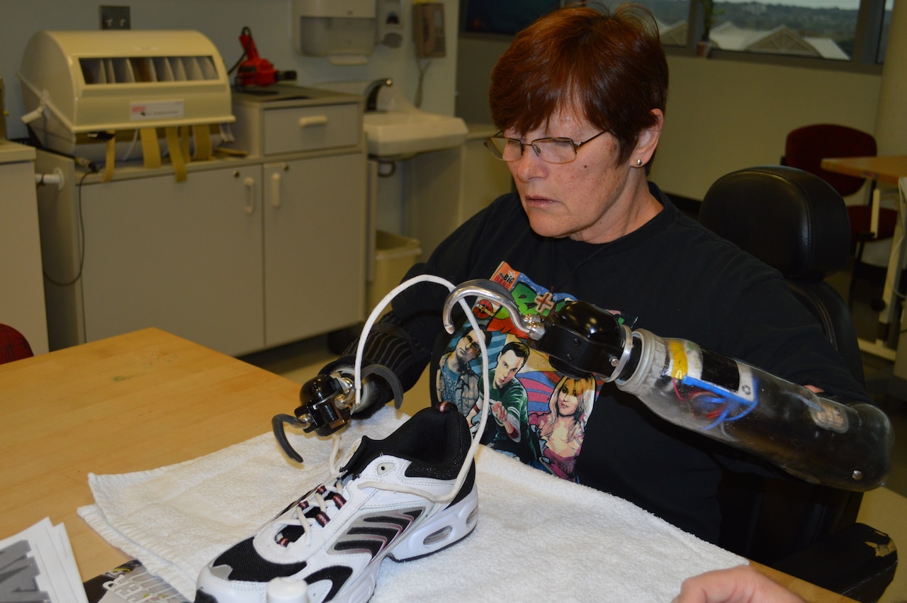 Donna Lowery works to put a shoe lace through the eyelet of a tennis shoe as part of her occupational therapy at the Center for the Intrepid at Joint Base San Antonio, Fort Sam Houston, Texas. U.S. Army photo by Lori Newman