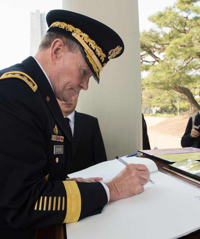 U.S. Army Gen. Martin E. Dempsey, chairman of the Joint Chiefs of Staff, writes in a guest book at the South Korean National Cemetery in Seoul, South Korea, March 27, 2015.
