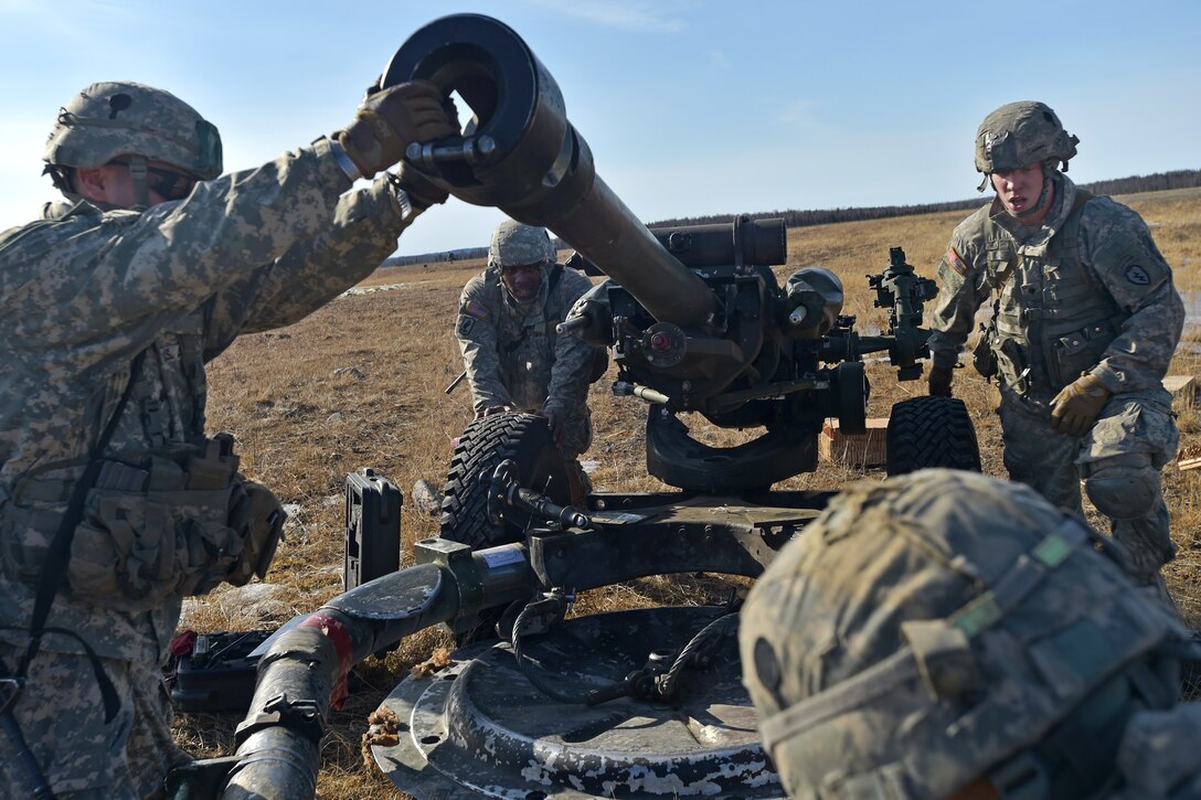 Paratroopers move a 105-mm howitzer into firing position after conducting a heavy drop and parachute assault during Operation Spartan Valkyrie at Malamute drop zone on Joint Base Elmendorf-Richardson, Alaska, March 20, 2015.