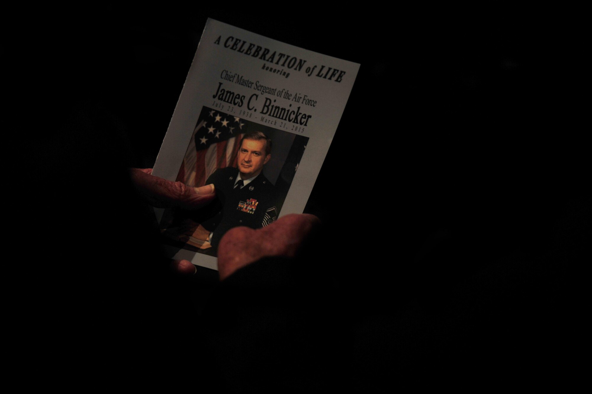 An attendee looks at a program during the celebration of life ceremony for Chief Master Sgt. of the Air Force #9 James C. Binnicker at the Emerald Coast Convention Center, Fort Walton Beach, Fla., March 28, 2015. More than 1,000 people attended Binnicker's celebration of life ceremony. He died March 21 in Calhoun, Ga. He was 76 years old. A memorial service and interment will be at Arlington National Cemetery, Virginia, at a later date. (U.S. Air Force photo by Airman 1st Class Ryan Conroy/Released)