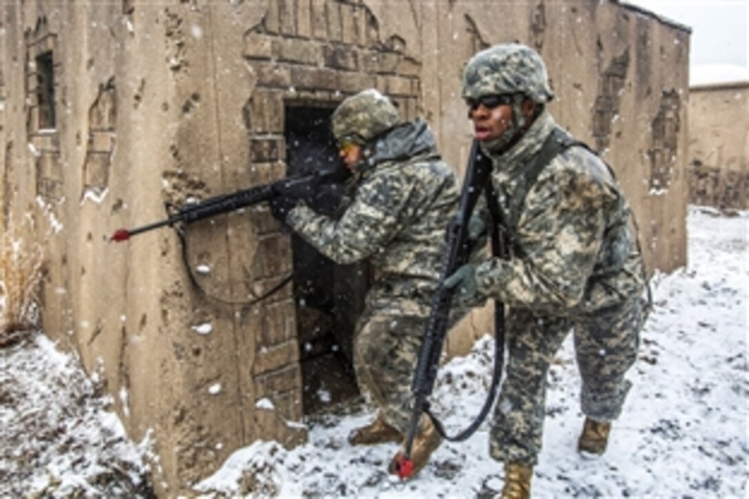 Army Sgt. Wilfredo S. Rodriguez-Ramos, left, provides cover fire as Army Pfc. Emery L. Bowens moves between buildings during battle drills at the training site for military operations in urban terrain on Joint Base McGuire-Dix-Lakehurst, N.J., March 20, 2015. Rodriguez-Ramos and Bowens are military police officers assigned to the New Jersey Army National Guard's 328th Military Police Company.