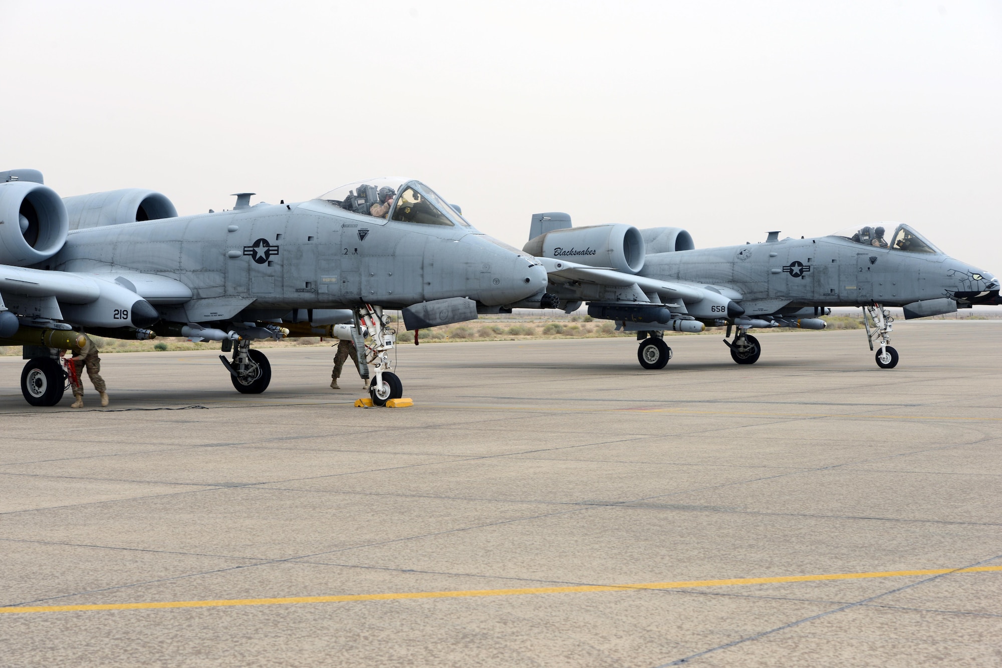 Two A-10 Thunderbolt IIs from the 163rd Expeditionary Fighter Squadron go through de-arming procedures following a mission March 16, 2015. Since their arrival to the 332nd Air Expeditionary Group here in late November, A-10s have expended nearly 50,000 rounds of ammunition and dropped approximately 500 bombs and maverick missiles in support of Operation INHERENT RESOLVE. (U.S. Air Force photo by Tech. Sgt. Jared Marquis)