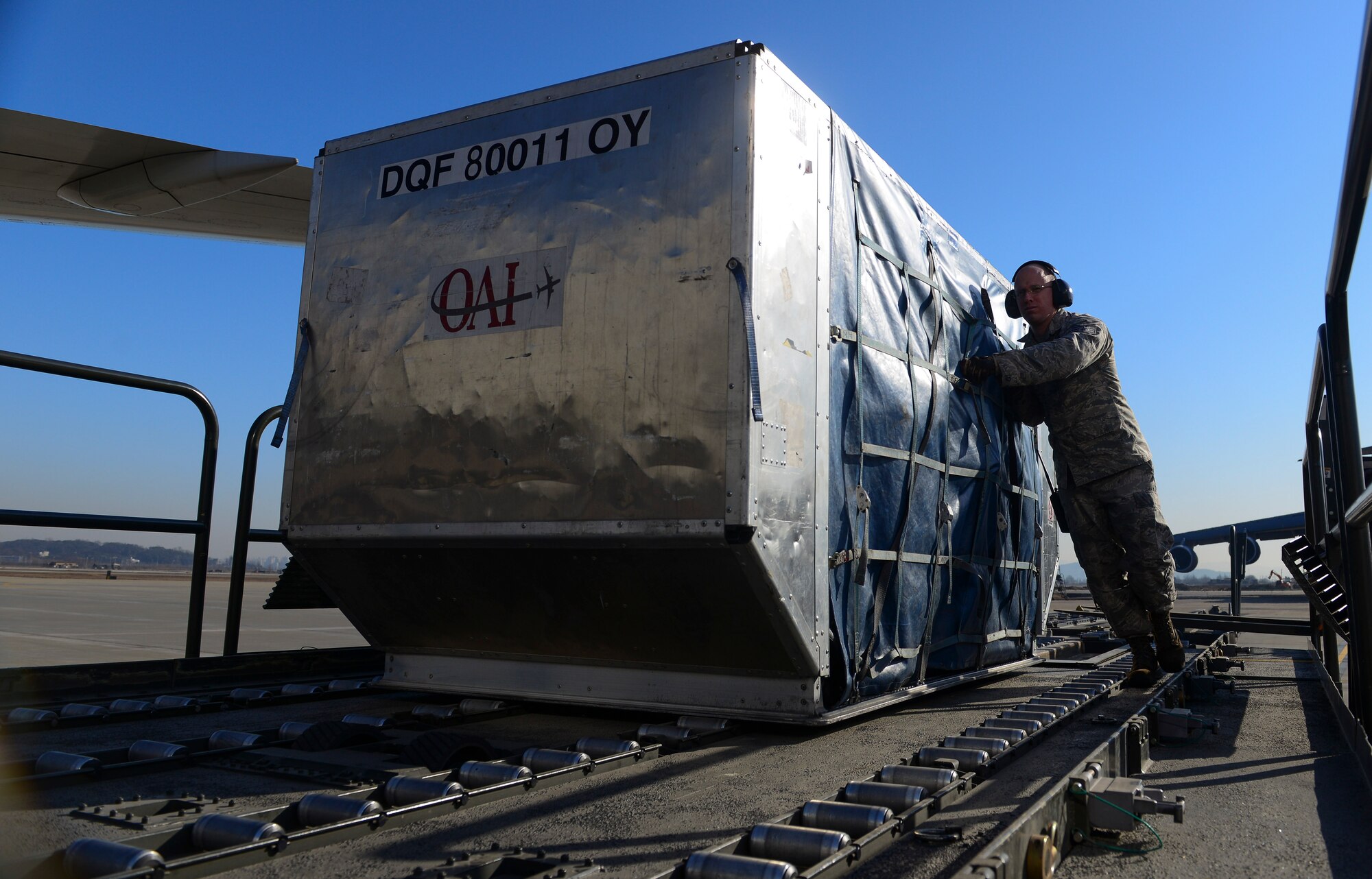 Staff Sgt. Kevin Mance, 731st Air Mobility Squadron aircraft services supervisor, pushes a baggage bin towards an aircraft March 12, 2015, at Osan Air Base, Republic of Korea. The new process has decreased personnel needed to operate from seven to five and a reduction in operating time down by 43 minutes. (U.S. Air Force photo by Senior Airman David Owsianka)