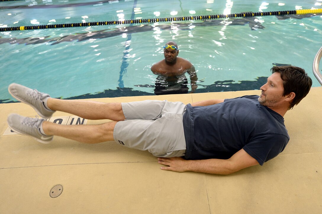 Swimming Coach Bobby Brewer, a 10-time member of the U.S. National Team and champion of the 100-meter backstroke in the 1998 U.S. Open and U.S. National Championships, gives retired Army Spc. Haywood Range III instruction on swim kicking during practice for the Army Trials on Fort Bliss in El Paso, Texas, March 28, 2015.