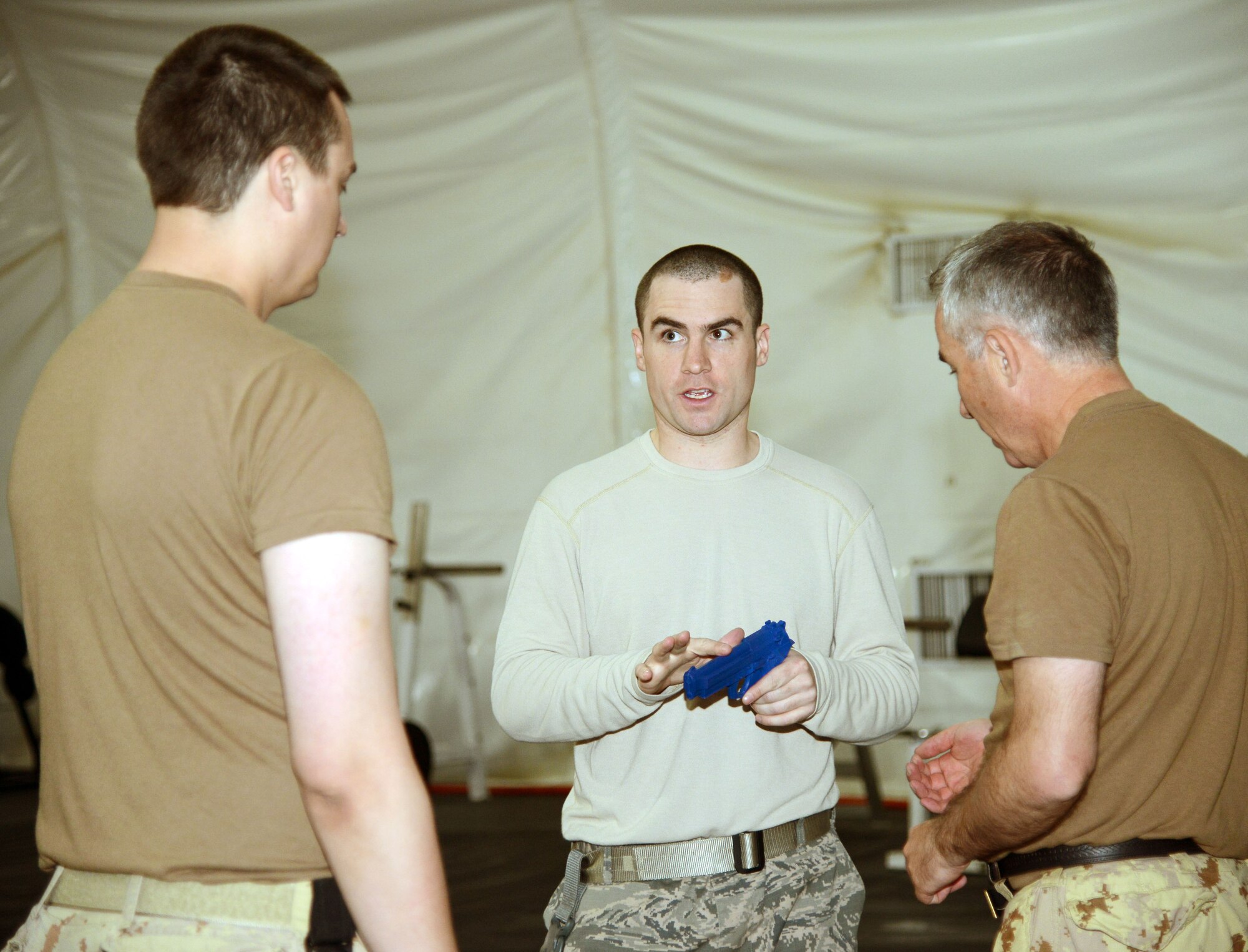 Staff Sgt. Christopher Crean, 386th Security Forces Squadron Check Six instructs two Canadian service members during a combatives class Feb. 22, 2015. The Check Six team taught the 10-hour self-defense class to 17 Canadian Armed Forces members. (U.S. Air Force photo by Tech. Sgt. Jared Marquis/released)