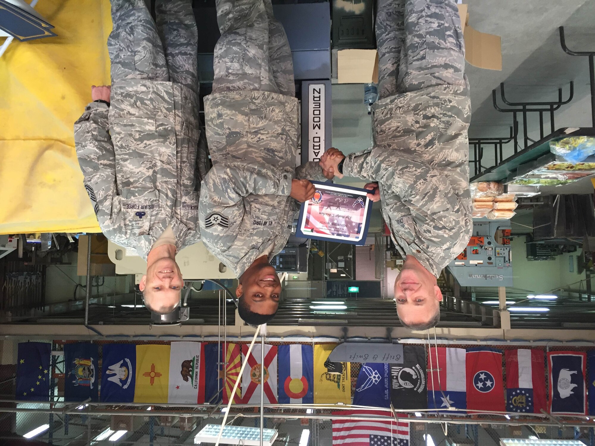 Staff Sgt. Booker Beacham (middle) accepts the NCO of the Month award for the 386th Expeditionary Maintenance Squadron. (Courtesy photo)