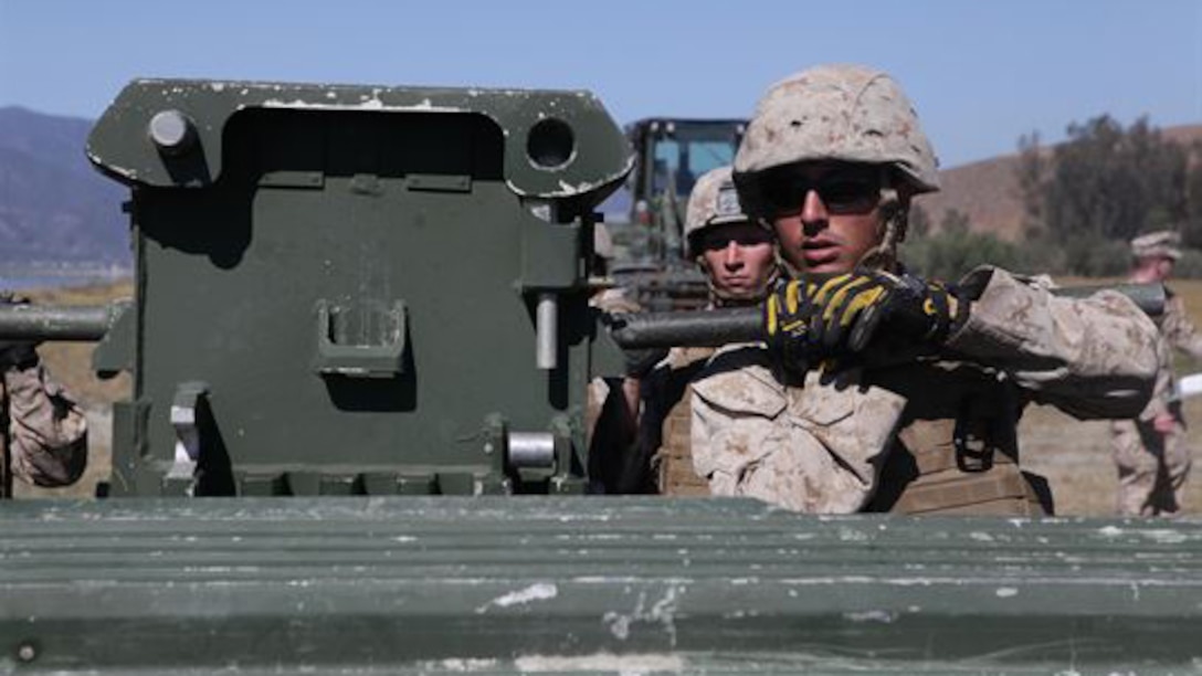 Marines from Bridge Company, 7th Engineer Support Battalion, 1st Marine Logistics Group, conduct a bridge exercise at Lake Elsinore, California, March 24, 2015. Marines built an improved ribbon bridge and a medium girder bridge. This event marks the first time a continuous span bridge from shore to shore has been built since 2002.