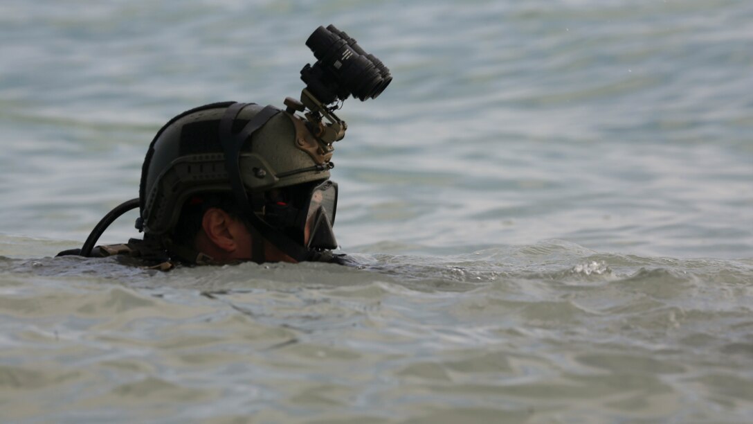 A 1st Marine Special Operations Battalion critical skills operator surfaces from the ocean and advances up a beach during a combat dive exercise in Key West, Fla., Feb. 18, 2015. The operator’s team spent a week in Key West practicing various maritime operations skill sets, further solidifying the development of their techniques, tactics and procedures and their standard operating procedures.