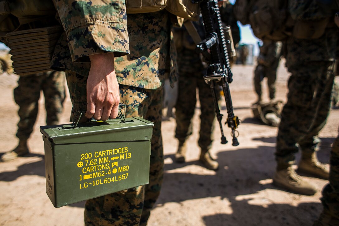 A U.S. Marine attending the infantry officers course holds an ammunition can before a fast rope training exercise in preparation for Talon Reach during Weapons and Tactics Instructor Course (WTI 2-15) at Auxiliary Airfield 2 near Yuma, AZ., March 26, 2015. WTI is a seven-week event hosted by Marine Aviation Weapons and Tactics Squadron One (MAWTS-1) cadre. MAWTS-1 provides standardized tactical training and certification of unit instructor qualifications to support Marine Aviation Training and Readiness and assists in developing and employing aviation weapons and tactics. (U.S. Marine Corps photo by Lance Cpl. Jodson B. Graves 2d MAW Combat Camera/Released)