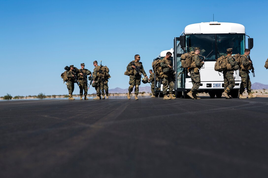 U.S. Marines attending the infantry officers course unload a bus prior to a fast rope training exercise in preparation for Talon Reach during Weapons and Tactics Instructor Course (WTI 2-15) at Auxiliary Airfield 2 near Yuma, AZ., March 26, 2015. WTI is a seven-week event hosted by Marine Aviation Weapons and Tactics Squadron One (MAWTS-1) cadre. MAWTS-1 provides standardized tactical training and certification of unit instructor qualifications to support Marine aviation Training and Readiness and assists in developing and employing aviation weapons and tactics. (U.S. Marine Corps photo by Lance Cpl. Jodson B. Graves 2d MAW Combat Camera/Released)
