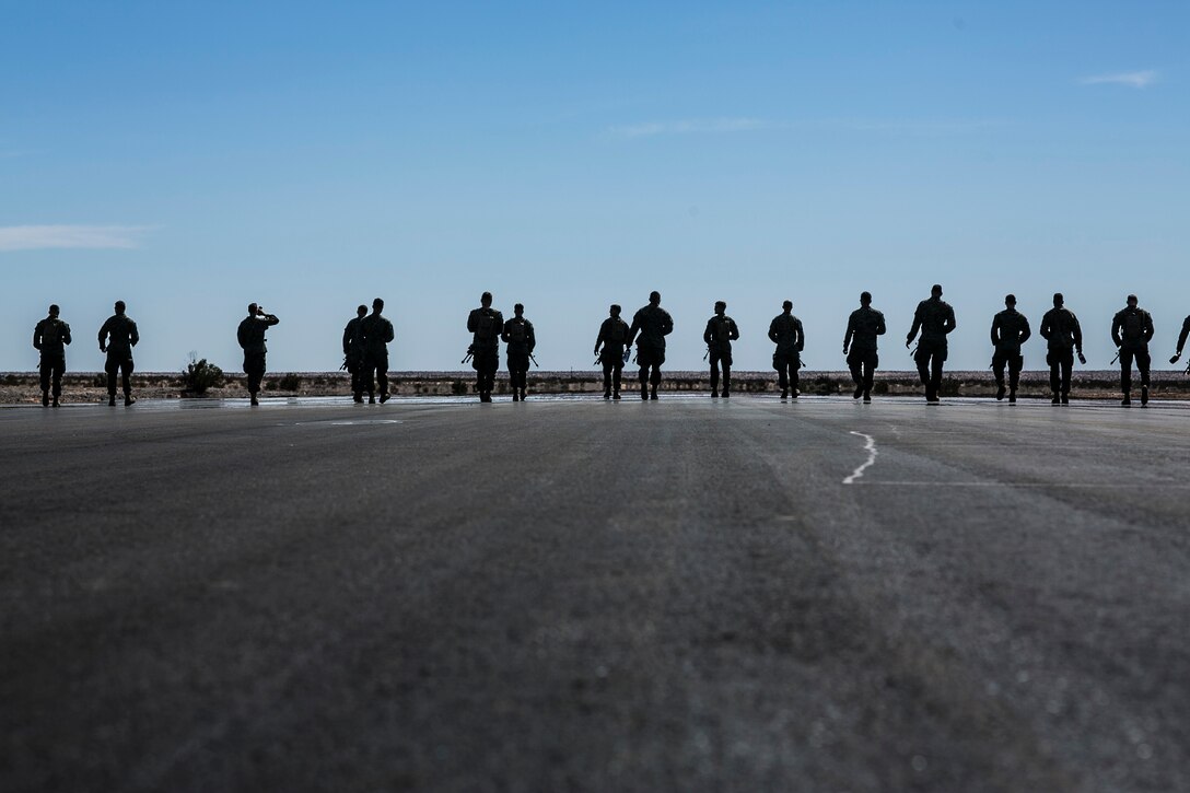 U.S. Marines attending the infantry officers course clear the flight line prior to a fast rope training exercise in preparation for Talon Reach during Weapons and Tactics Instructor Course (WTI 2-15) at Auxiliary Airfield 2 near Yuma, AZ., March 26, 2015. WTI is a seven-week event hosted by Marine Aviation Weapons and Tactics Squadron One (MAWTS-1) cadre. MAWTS-1 provides standardized tactical training and certification of unit instructor qualifications to support Marine aviation Training and Readiness and assists in developing and employing aviation weapons and tactics. (U.S. Marine Corps photo by Lance Cpl. Jodson B. Graves 2d MAW Combat Camera/Released)