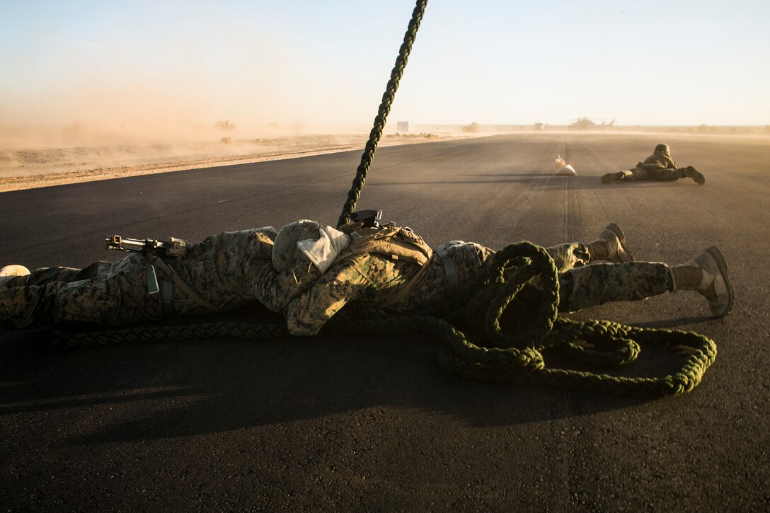 U.S. Marines attending the infantry officers course secure a rappel rope during fast rope training in preparation for Talon Reach during Weapons and Tactics Instructor Course (WTI 2-15) at Auxiliary Airfield 2 near Yuma, AZ., March 26, 2015. WTI is a seven-week event hosted by Marine Aviation Weapons and Tactics Squadron One (MAWTS-1) cadre. MAWTS-1 provides standardized tactical training and certification of unit instructor qualifications to support Marine aviation Training and Readiness and assists in developing and employing aviation weapons and tactics. (U.S. Marine Corps photo by Lance Cpl. Jodson B. Graves 2d MAW Combat Camera/Released)