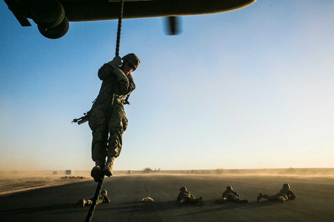 U.S. Marines attending the infantry officers course conduct fast rope training in preparation for Talon Reach during Weapons and Tactics Instructor Course (WTI 2-15) at Auxiliary Airfield 2 near Yuma, AZ., March 26, 2015. WTI is a seven-week event hosted by Marine Aviation Weapons and Tactics Squadron One (MAWTS-1) cadre. MAWTS-1 provides standardized tactical training and certification of unit instructor qualifications to support Marine aviation Training and Readiness and assists in developing and employing aviation weapons and tactics. (U.S. Marine Corps photo by Lance Cpl. Jodson B. Graves 2d MAW Combat Camera/Released)