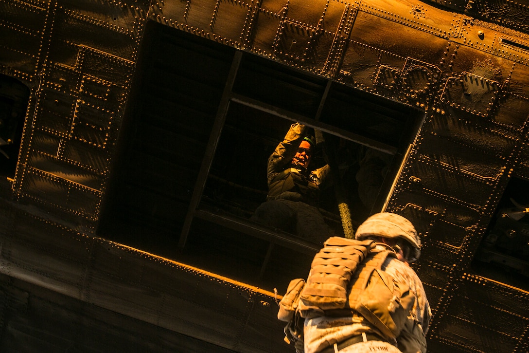 U.S. Marine Corps Sgt. David W. Berry, a helicopter rope suspension technique master attending the infantry officers course, guides students descent from a CH53E Super Stallion during fast rope training in preparation for Talon Reach during Weapons and Tactics Instructor Course (WTI 2-15) at Auxiliary Airfield 2 near Yuma, AZ., March 26, 2015. WTI is a seven-week event hosted by Marine Aviation Weapons and Tactics Squadron One (MAWTS-1) cadre. MAWTS-1 provides standardized tactical training and certification of unit instructor qualifications to support Marine aviation Training and Readiness and assists in developing and employing aviation weapons and tactics. (U.S. Marine Corps photo by Lance Cpl. Jodson B. Graves 2d MAW Combat Camera/Released)