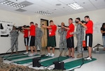 Soldiers from the Florida National Guard's 53rd Infantry Brigade Combat Team's rear detachment assist participants in the NFL's High School Player Development program in operating simulated weapons while touring the Armed Forces Reserve Center in Pinellas Park, Fla. The HSPD and 53rd IBCT rear detachment teamed up to assemble care packages for deployed Florida National Guardsmen, July 9.