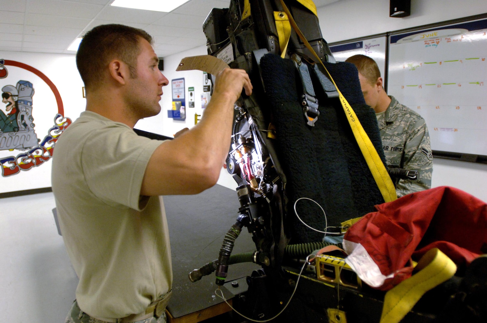 Staff Sgt. Ronald Kavanaugh and Airman 1st Class William Stanton inspect an ejection seat from an F-22 Raptor at Langley Air Force Base, Va., May 12, 2010. Each ejection system undergoes a final inspection every 30 days, where technicians physically inspect every component of the system they can touch. Kavanaugh is an egress technician with the Virginia Air National Guard’s 192nd Fighter Wing. Stanton is an egress apprentice with the 1st Component Maintenance Squadron.