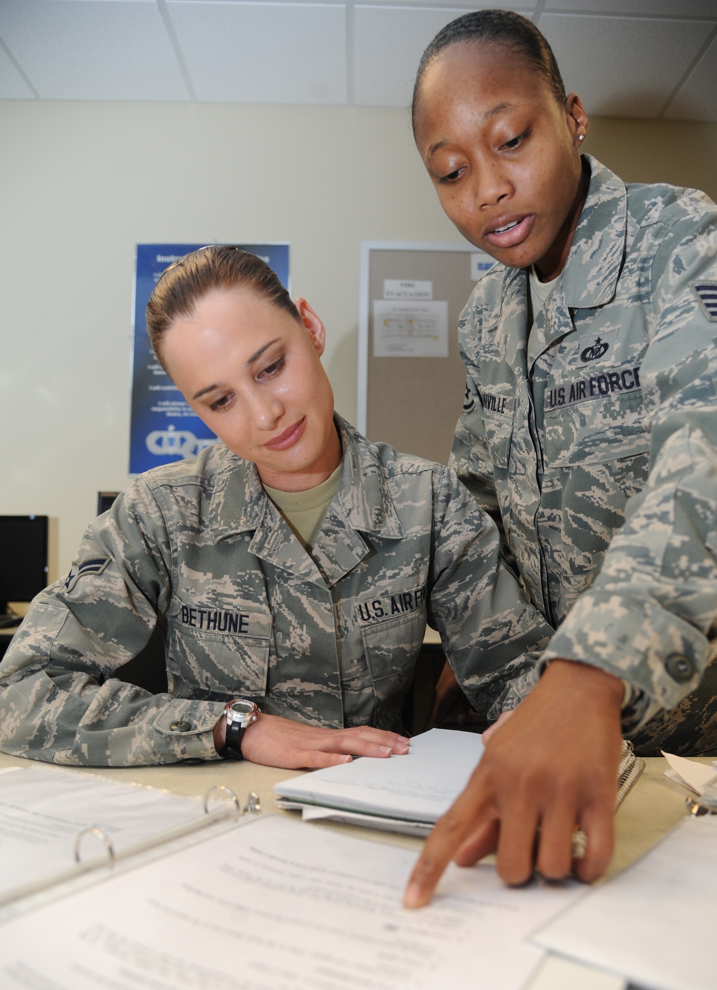 Airman 1st Class Tiffany Bethune, 334th Training Squadron student, reviews notes with Staff Sgt. Betty Granville, 334th TRS instructor, for her course exam during the aviation resource management apprentice course March 24, 2015, at Cody Hall, Keesler Air Force Base, Miss. Bethune graduates with perfect scores March 26, and will head to the 79th Rescue Squadron, Davis-Monthan Air Force Base, Ariz.  (U.S. Air Force photo by Kemberly Groue)