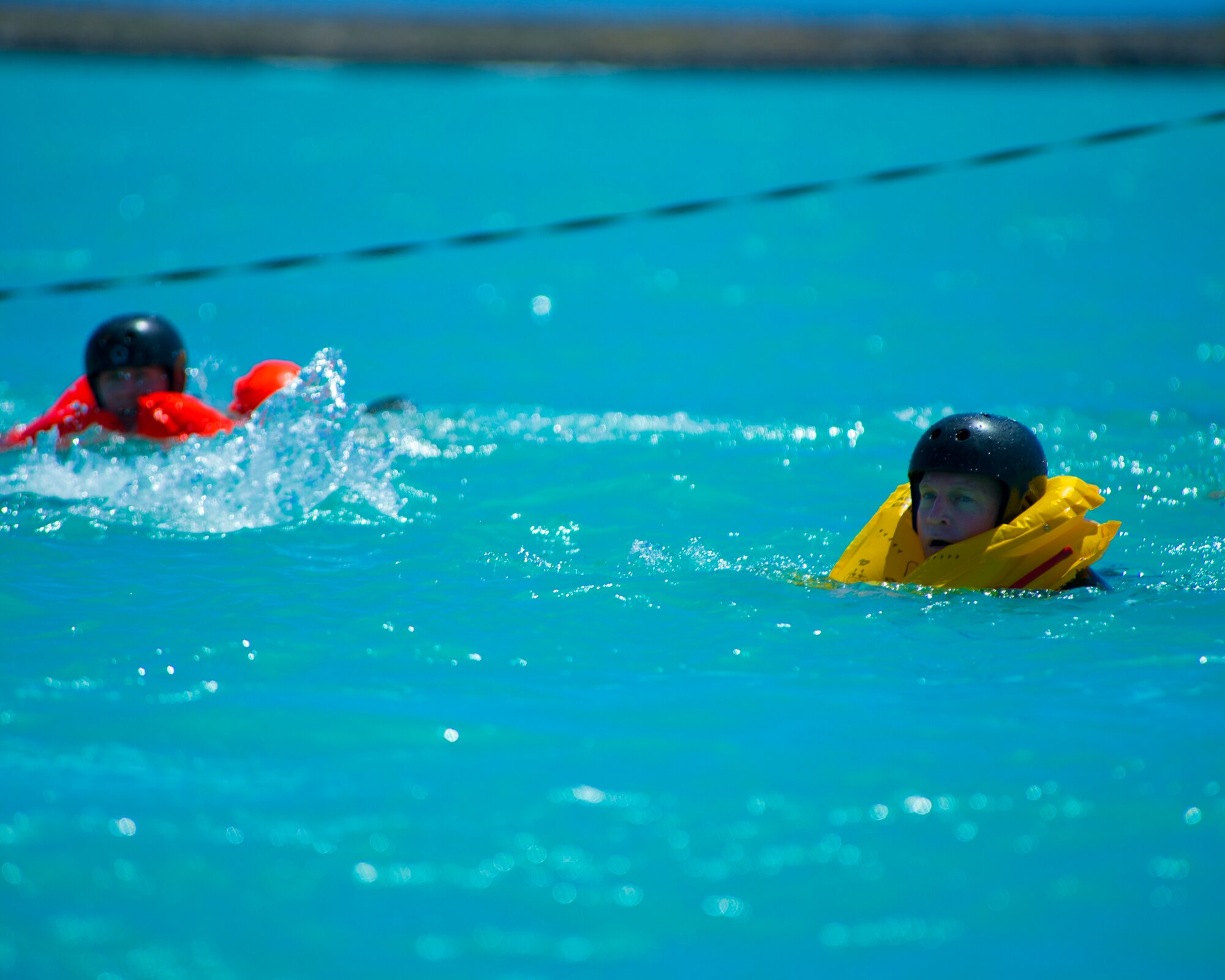 Lt. Col. David Hammer, the director of operations for the 65th Airlift Squadron, swims towards the dock at Hickam Harbor after egressing from a 46person life raft during water survival training on Joint Base Pearl Harbor-Hickam, Hawaii, March 23, 2015. The water survival training is a triennial requirement for all aircrew. (U.S. Air Force photo by Tech. Sgt. Aaron Oelrich/Released)  