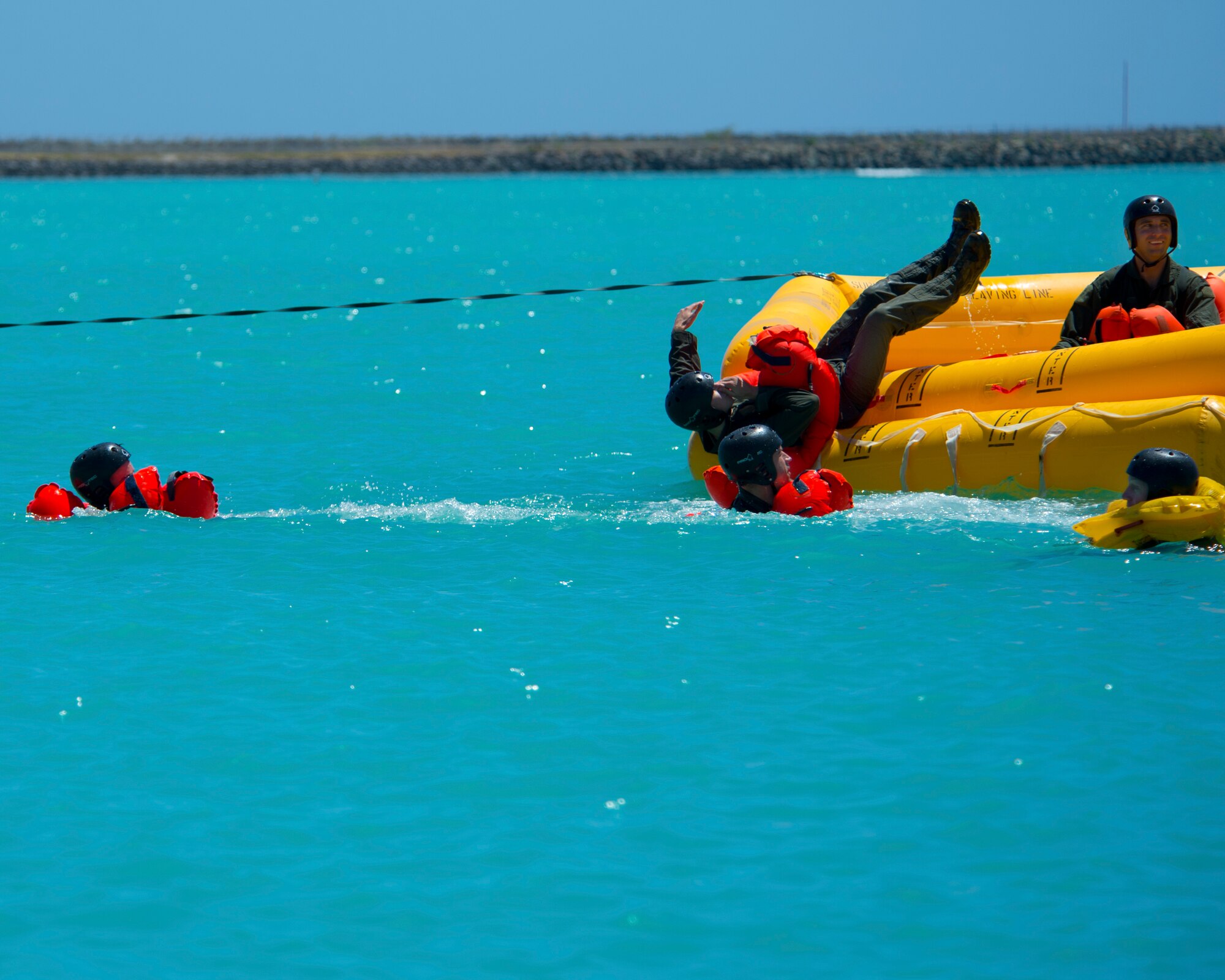 Airmen from the 535th Airlift Squadron, 65th Airlift Squadron and the 96th Air Refueling Squadron, egress from a 46-man life raft during water survival training on Joint Base Pearl Harbor-Hickam, Hawaii, March 23, 2015. Water survival training is completed on triennial basis for all aircrew assigned to the 15th Wing. (U.S. Air Force photo by Tech. Sgt. Aaron Oelrich/Released)  