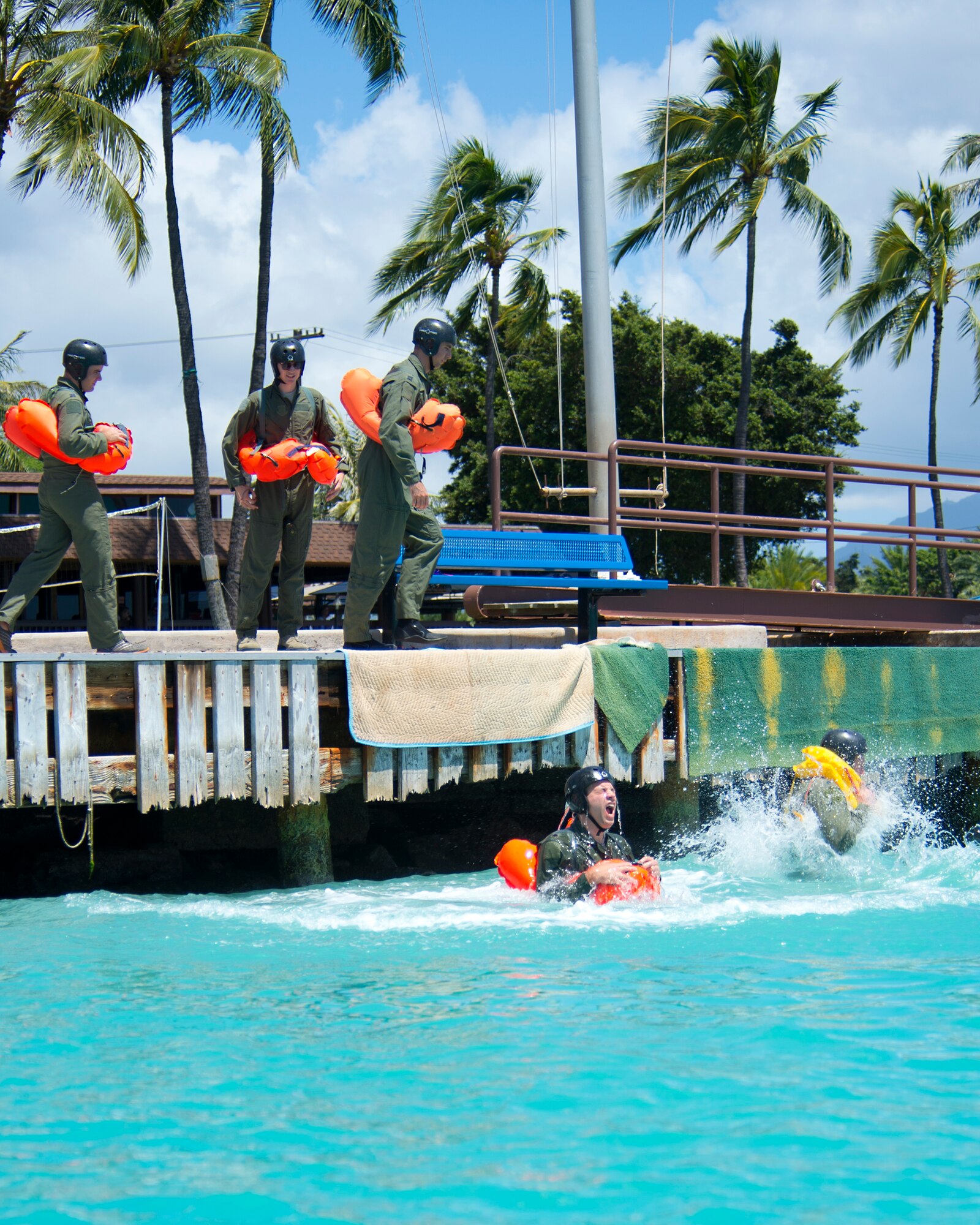 Airmen from the 535th Airlift Squadron, 65th Airlift Squadron and the 96th Air Refueling Squadron jump into Hickam Harbor to simulate exiting an aircraft that has landed in the ocean during water survival training on Joint Base Pearl Harbor-Hickam, Hawaii, March 23, 2015. Water survival training is completed on triennial basis for all aircrew assigned to the 15th Wing. (U.S. Air Force photo by Tech. Sgt. Aaron Oelrich/Released) 