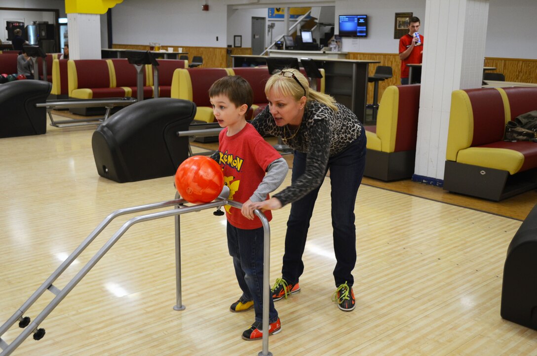 Jill Stone helps her son set up his bowling ball during the mother-son bowling event at the Quantico Bowling Center on Friday. 