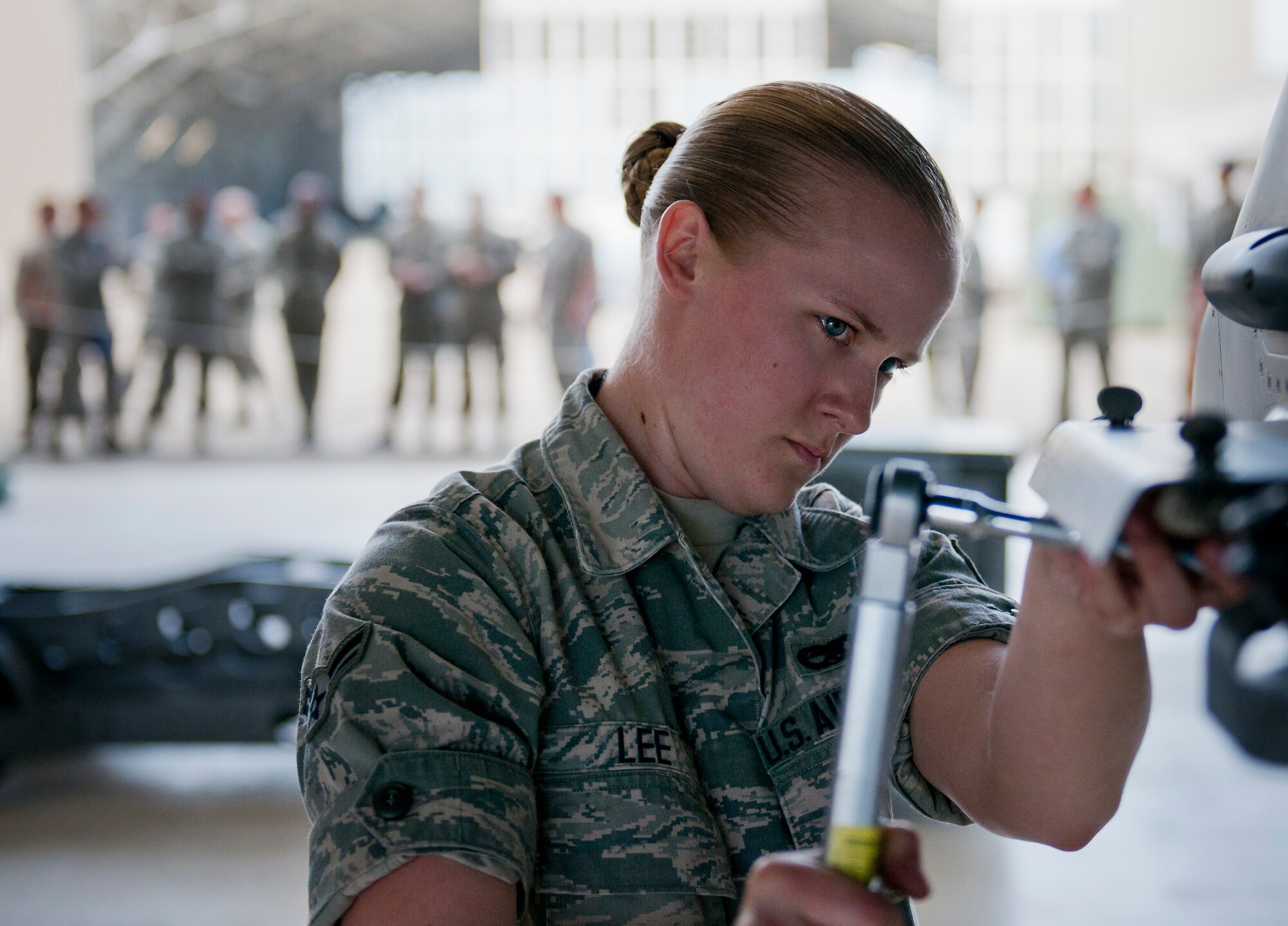 A group of maintainers watch as Airman 1st Class Kyndle Lee, 96th Aircraft Maintenance Squadron, prepares an F-16 Fighting Falcon for a weapon during the squadron’s first quarter weapons load competition March 19 at Eglin Air Force Base, Fla.  The Red F-15 Eagle team battled the Blue F-16 crew for quickest and most accurate load of a bomb and missile on their respective aircraft.  (U.S. Air Force photo/Samuel King Jr.)