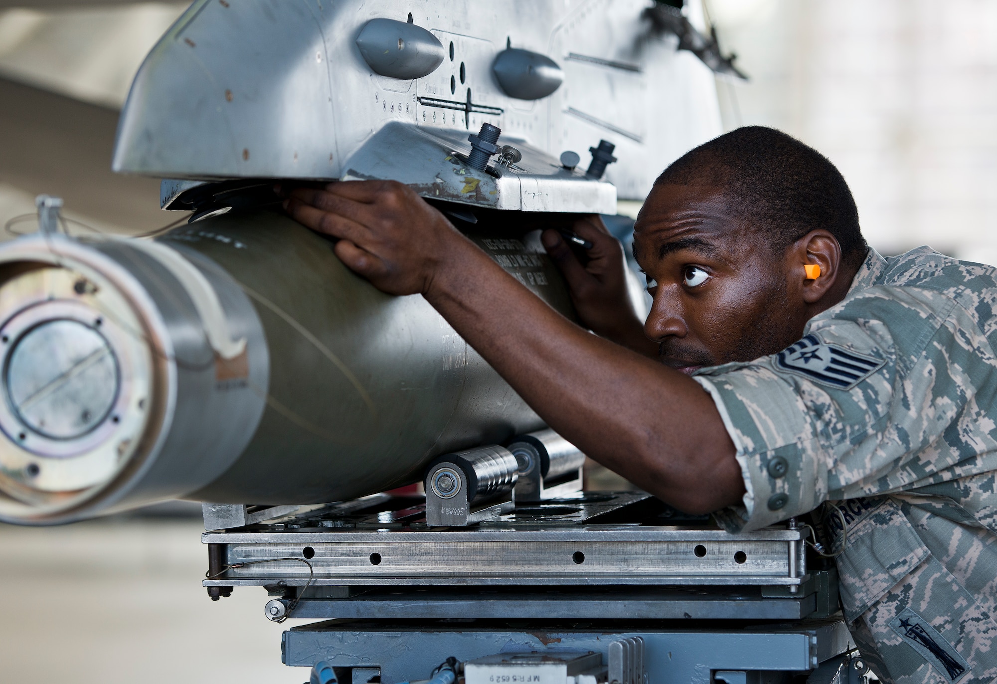 Staff Sgt. Roger Godwin, 96th Aircraft Maintenance Squadron, secures an MK-82 bomb to an F-16 Fighting Falcon during the squadron’s first quarter weapons load competition March 19 at Eglin Air Force Base, Fla.  The Red F-15 Eagle team battled the Blue F-16 crew for quickest and most accurate load of a bomb and missile on their respective aircraft.  (U.S. Air Force photo/Samuel King Jr.)