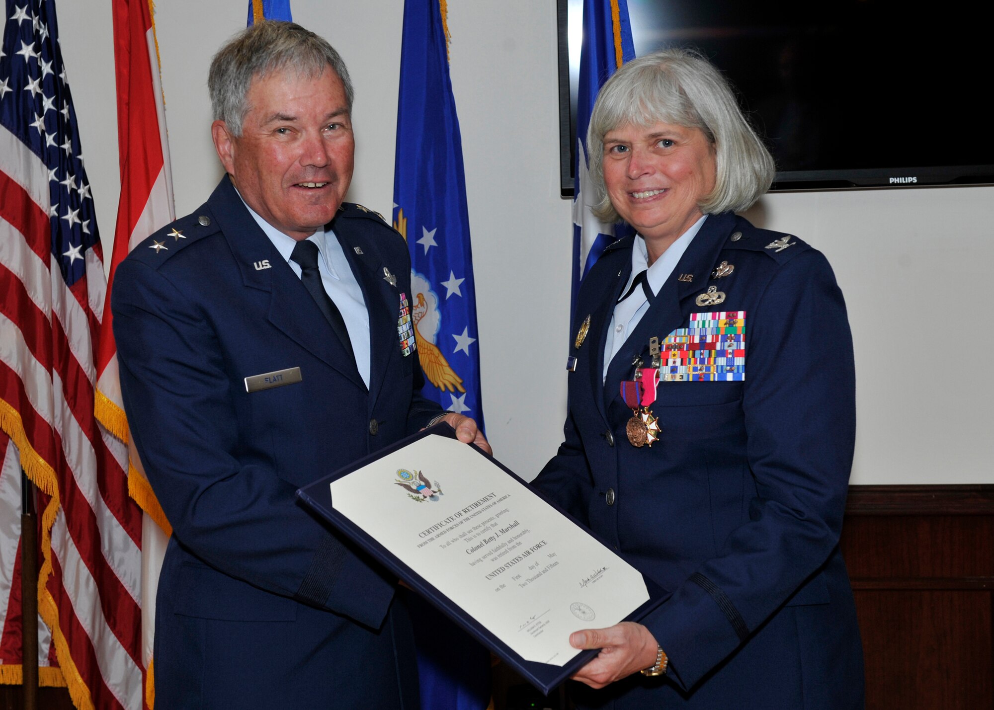 Maj. Gen. (Ret.) Richard Platt presents Col. “BJ” Marshall with her Air Force Certificate of Retirement during her ceremony March 20. When Marshall, previously Director of Installations and Mission Support for Continental U.S. NORAD Region-1st AF (Air Forces Northern), received her commission in the U.S. Air Force in 1990, Platt presided over her ceremony. (U.S. Air Force photo by Airman 1st Class Sergio Gamboa/Released)